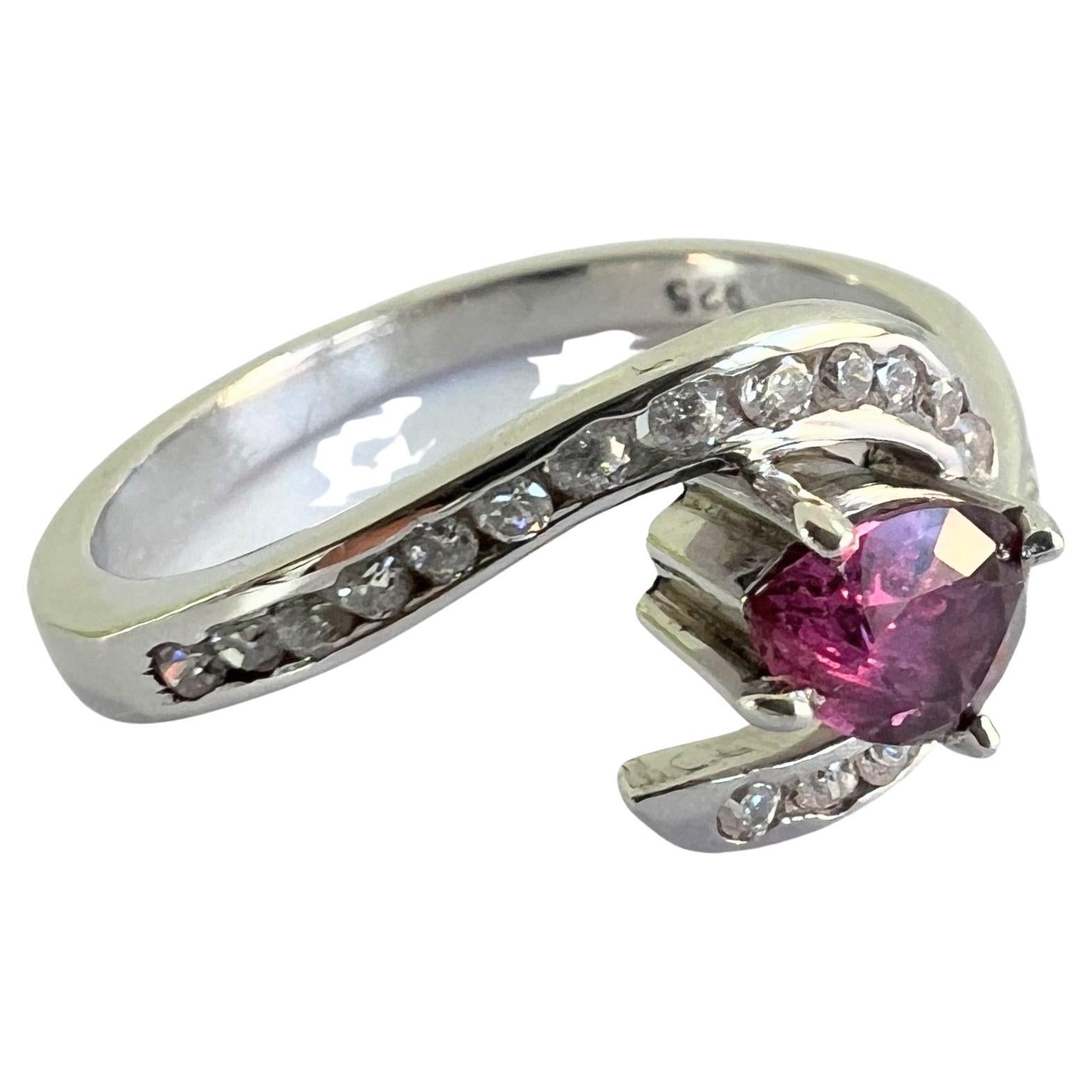 Indulge in the ultimate expression of love and luxury with this EGL Certified 1ct Pink Sapphire Ring on Natural Platinum Coated Silver. This enchanting piece showcases a 5.8x4.8mm pear-shaped natural origin pink sapphire, radiating with a soft,