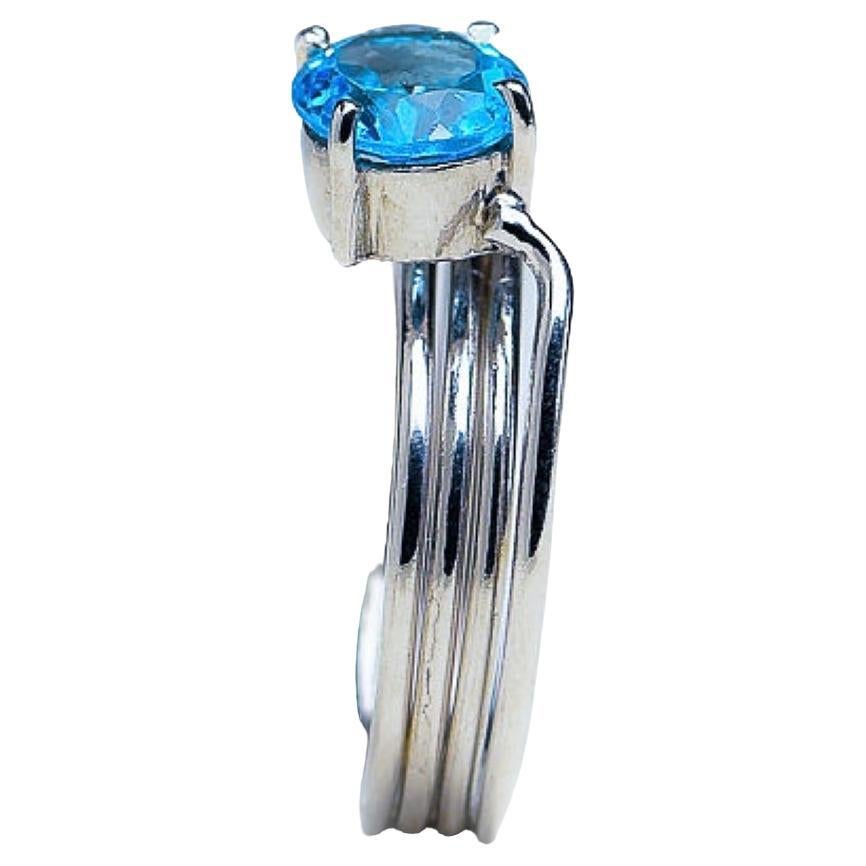 Wir präsentieren unseren 1ct Round Blue Topaz Platinum Silver Band Ring. Dieses elegante Stück enthält einen atemberaubenden Blautopas von 1 Karat, der für seinen leuchtend blauen Farbton und seine Klarheit bekannt ist. Der blaue Topas ist in einem