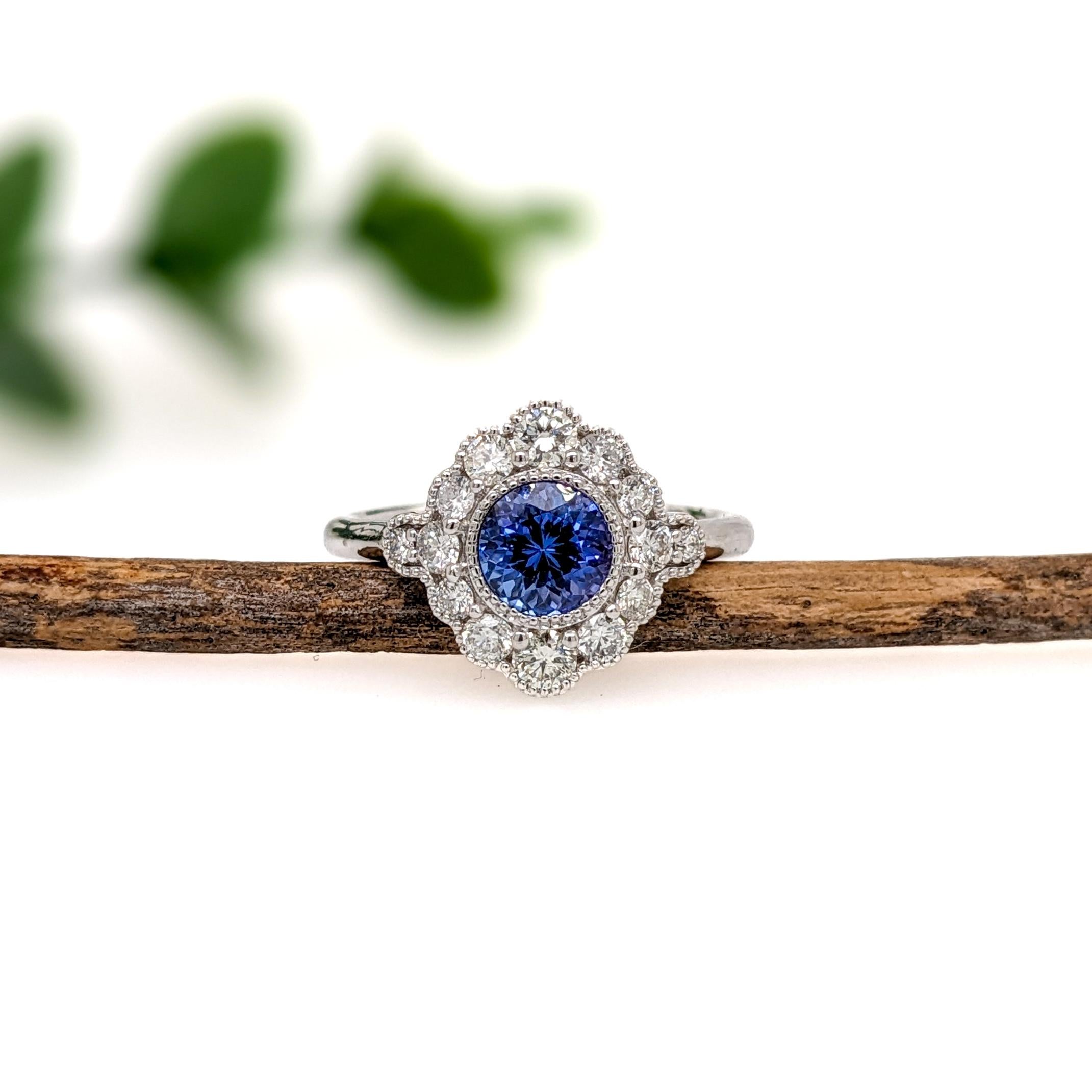 This beautiful ring features a 0.99 carat Tanzanite gemstone, encircled by a halo of natural earth mined diamonds and milgrain detail, all set in solid 14K gold. Perfect for making a statement, this cocktail ring is both elegant and eye-catching.