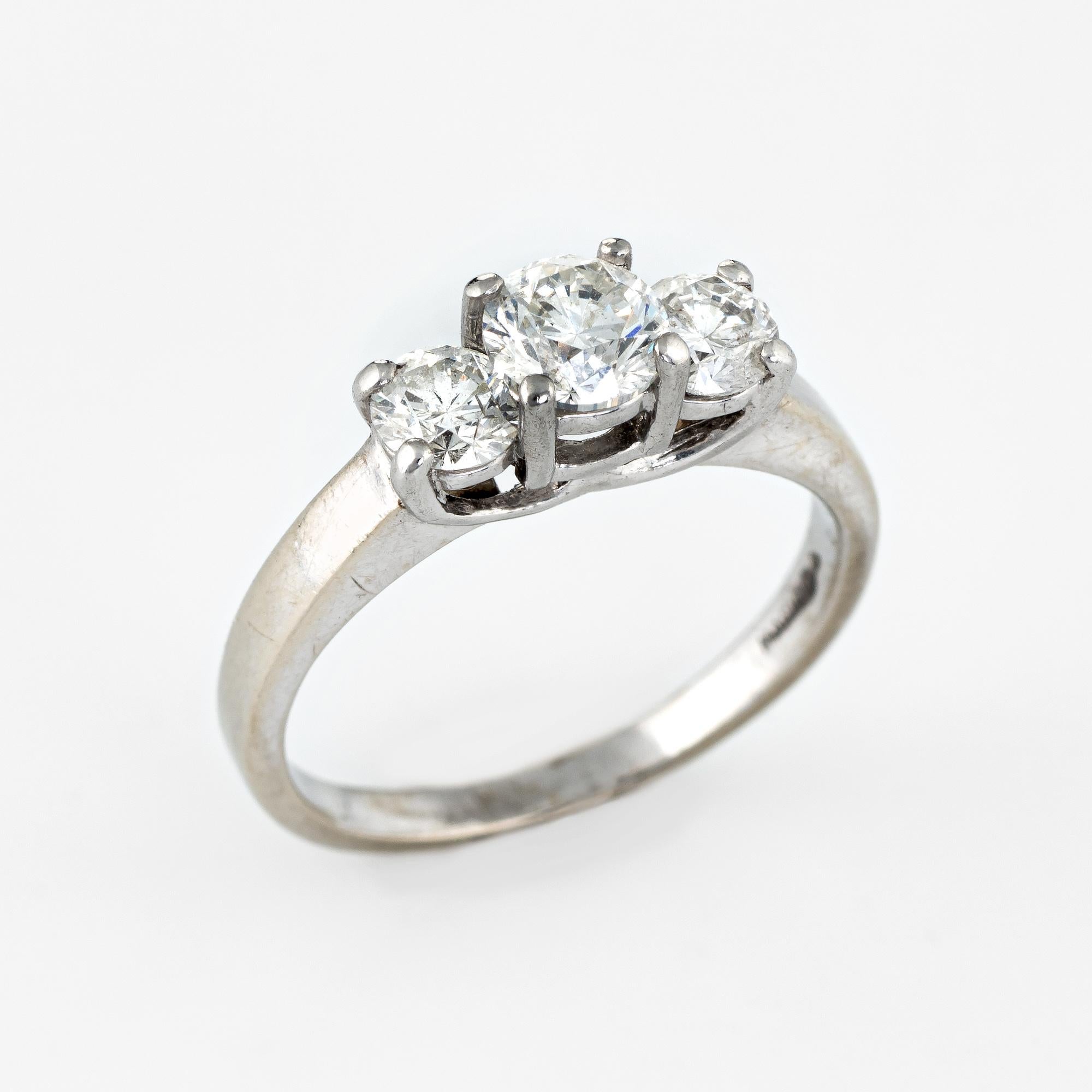 Stylish estate three diamond 'trilogy' ring crafted in 14 karat white gold and 900 platinum. 

Three round brilliant cut diamonds are set into the mount. The center diamond is estimated at 0.50 carats with the two side diamonds estimated at 0.25