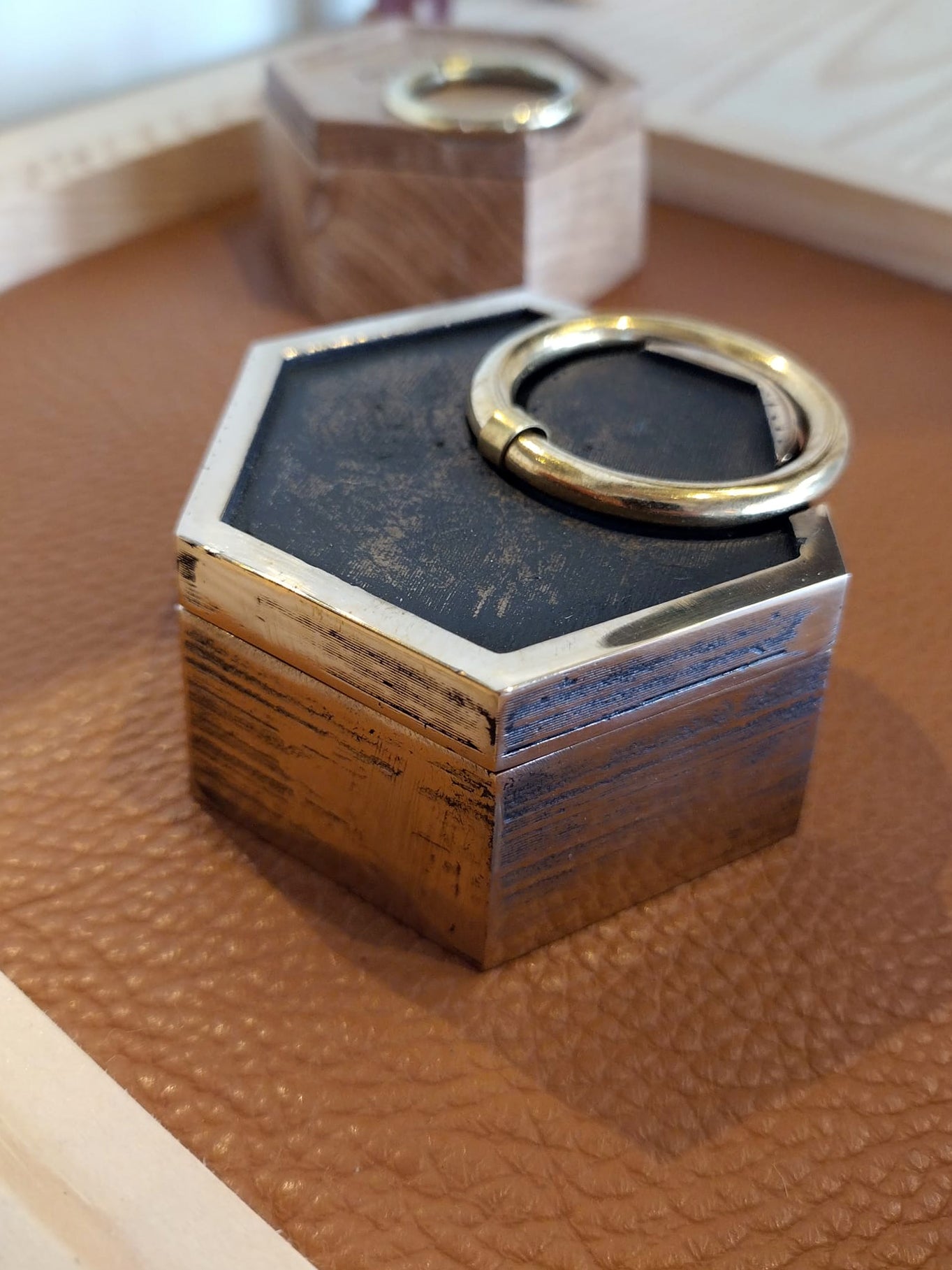 Cette boîte à bijoux, conçue à partir des poids officiels de 1 kg, est unique en son genre. Disponible en bronze massif, ou en chêne français (DM us), la partie inférieure intérieure est recouverte d'un beau cuir cognac brun naturel. L'anneau du