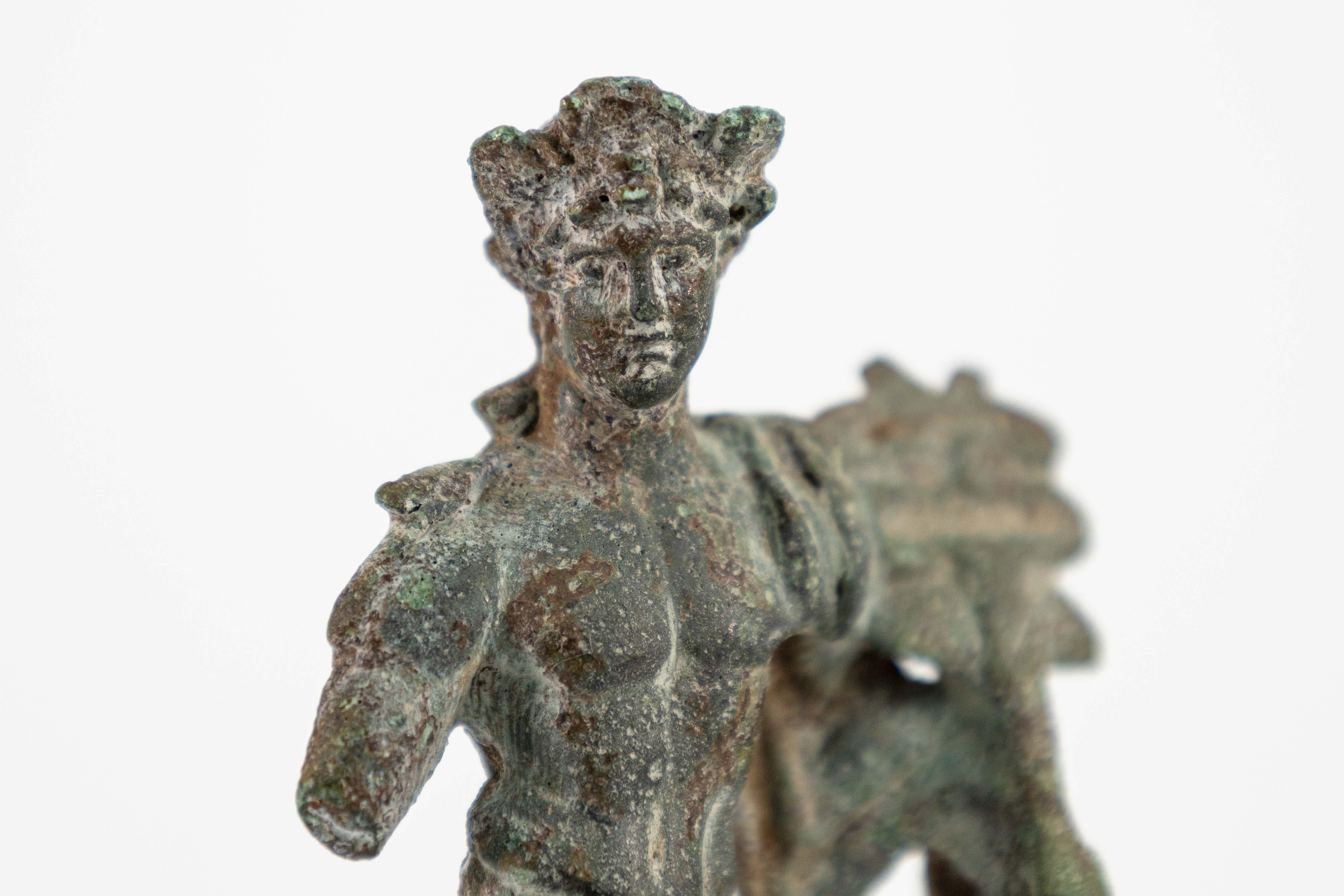 Un manufatto storico unico nel suo genere: una statuetta romana in bronzo di Mercurio, che regge un caduceo, con ariete al fianco, di stile politeista. Circa il I secolo d.C. Esposto su un piedistallo di base. Polykleitos era uno scultore greco del