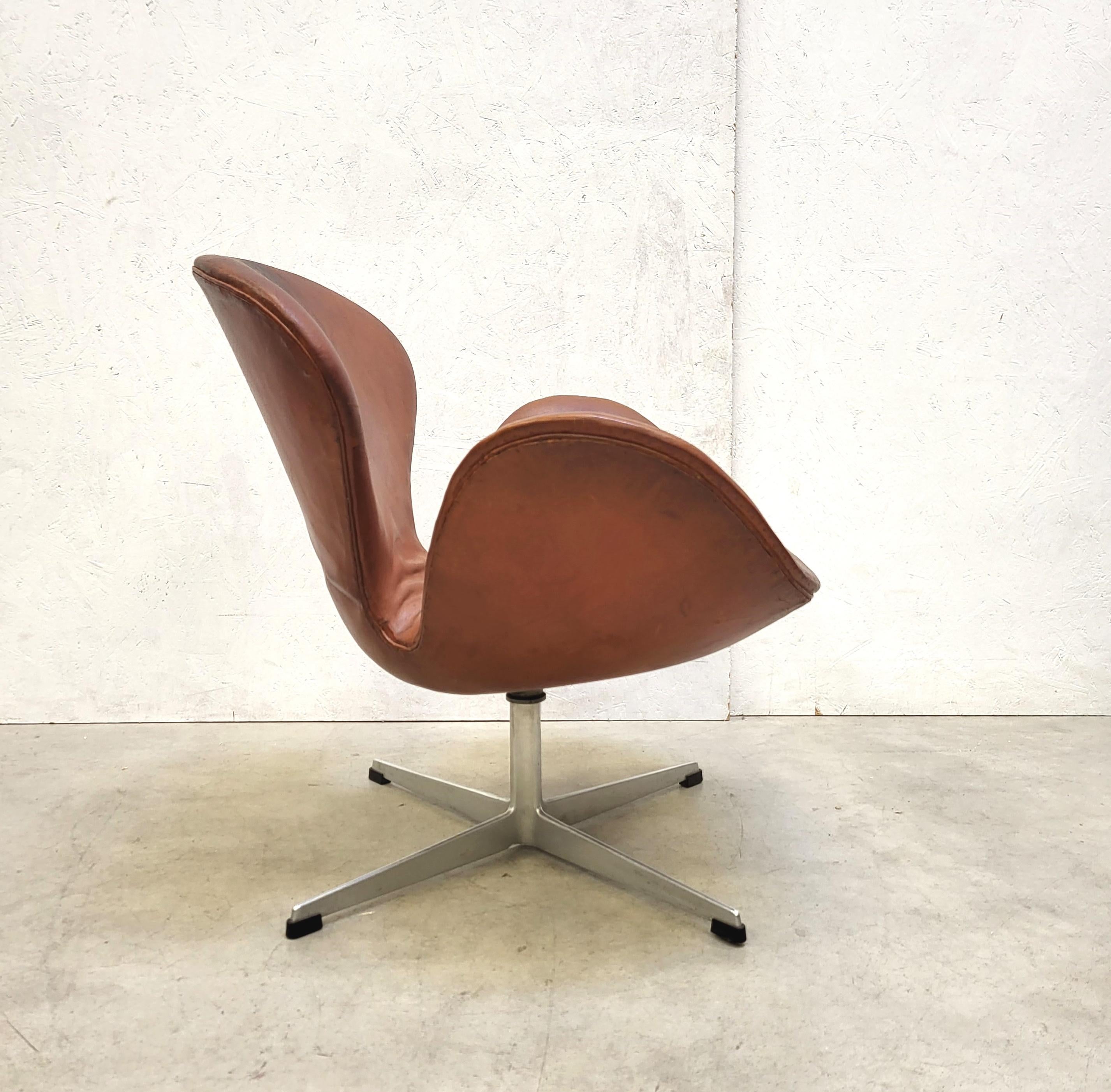 This very rare 1st edition Swan chair was designed in the 1950s by Arne Jacobsen for the SAS Hotel in Copenhagen and produced by Fritz Hansen around 1958/1959. 

The chair features a wonderful cognac leather upholstery which shows an amazing