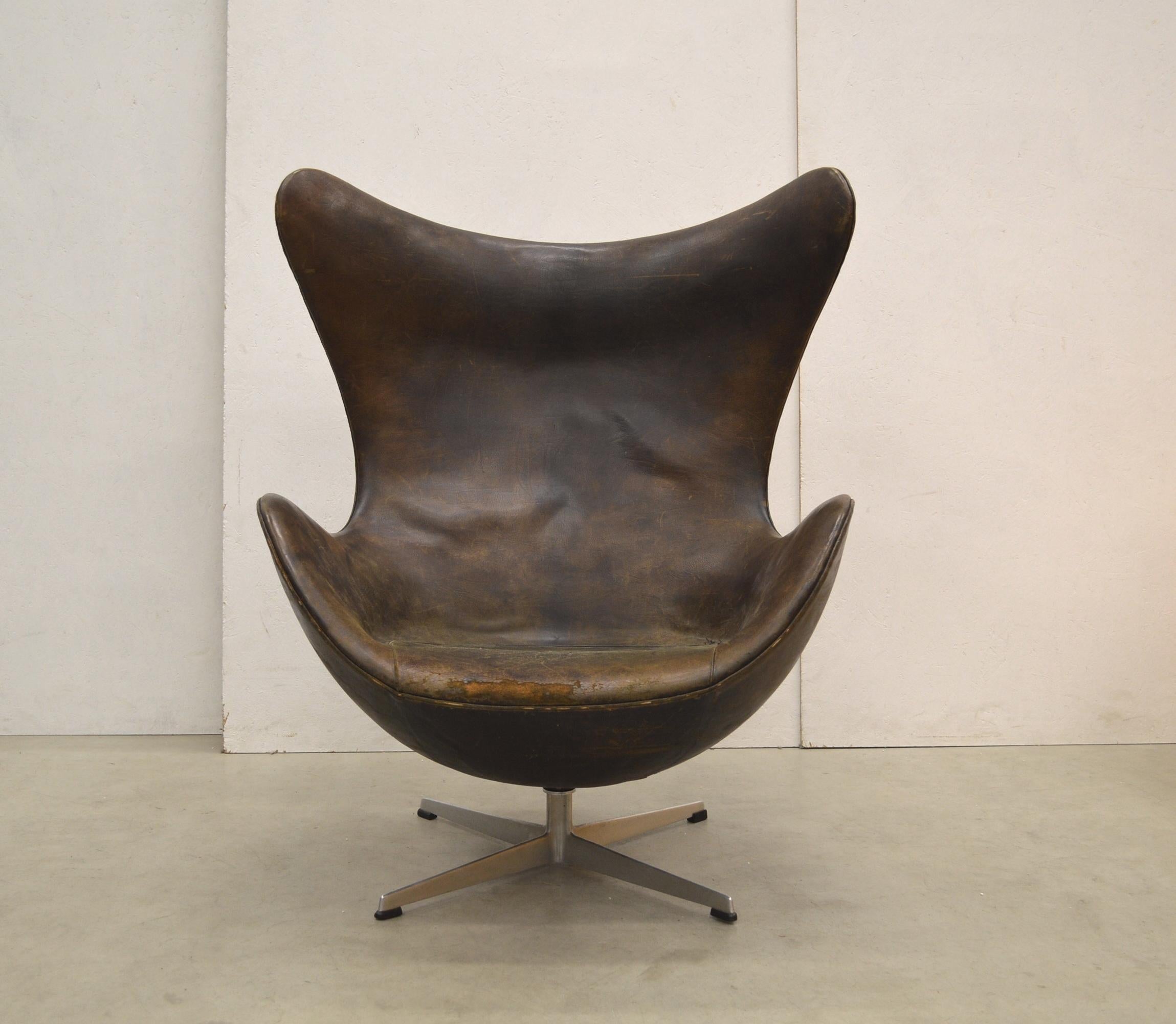 This very rare 1st edition egg chair was designed in the 50s by Arne Jacobsen for the SAS Hotel in Copenhagen and produced by Fritz Hansen around 1958/1959. The chair features a wonderful brown black leather upholstery which shows an amazing patina.