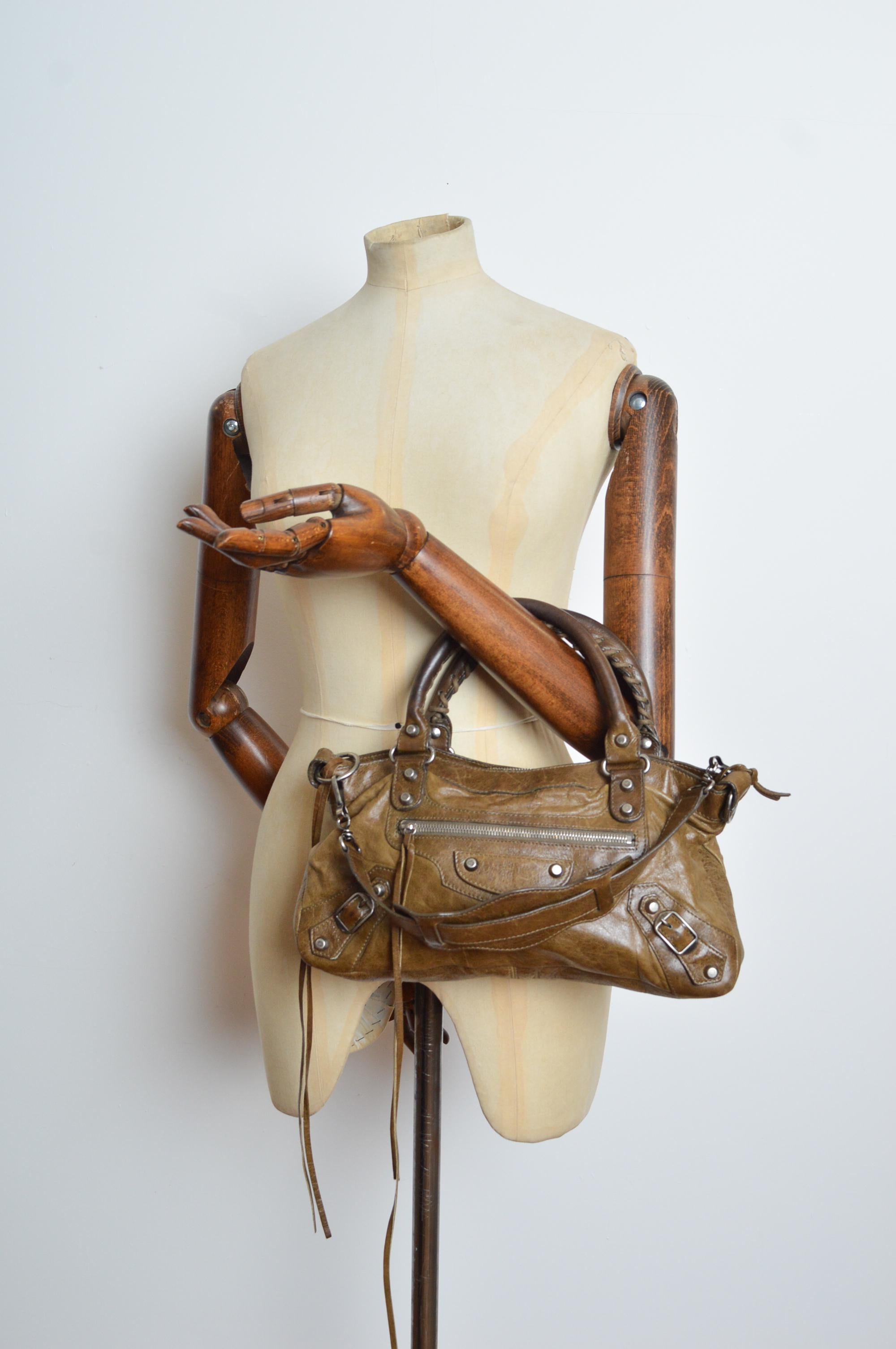 1st Edition BALENCIAGA Mud Brown / Khaki coloured natural Leather 'Motorcycle bag'. 
Features; 2 Top handles, detachable shoulder strap, Zip closure top, Black cotton lining, Various compartments including zip sections & Original Leather covered