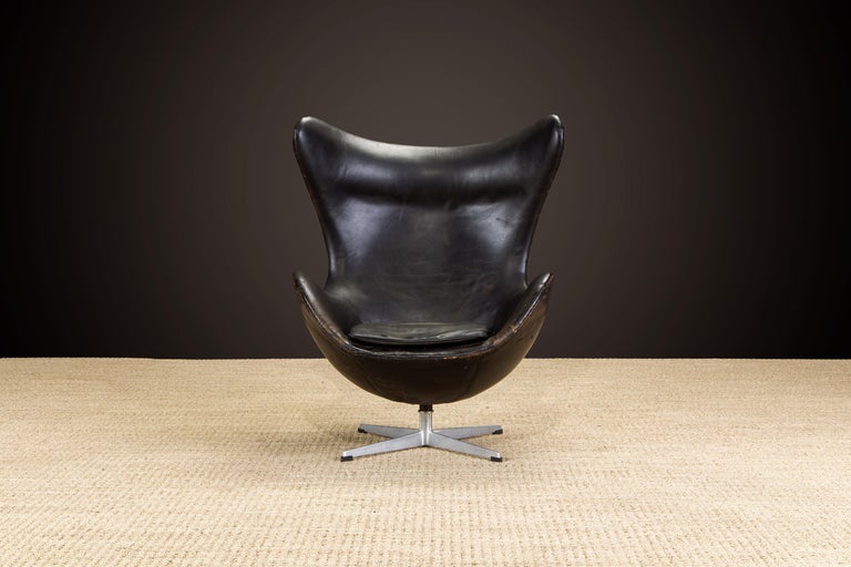 This iconic original black leather 'Egg' chair by Arne Jacobsen is a very early, circa 1958 production by Fritz Hansen and signed underneath on the leather with the FH stamp and partial Danish Control label (see last photo). Examples with this style