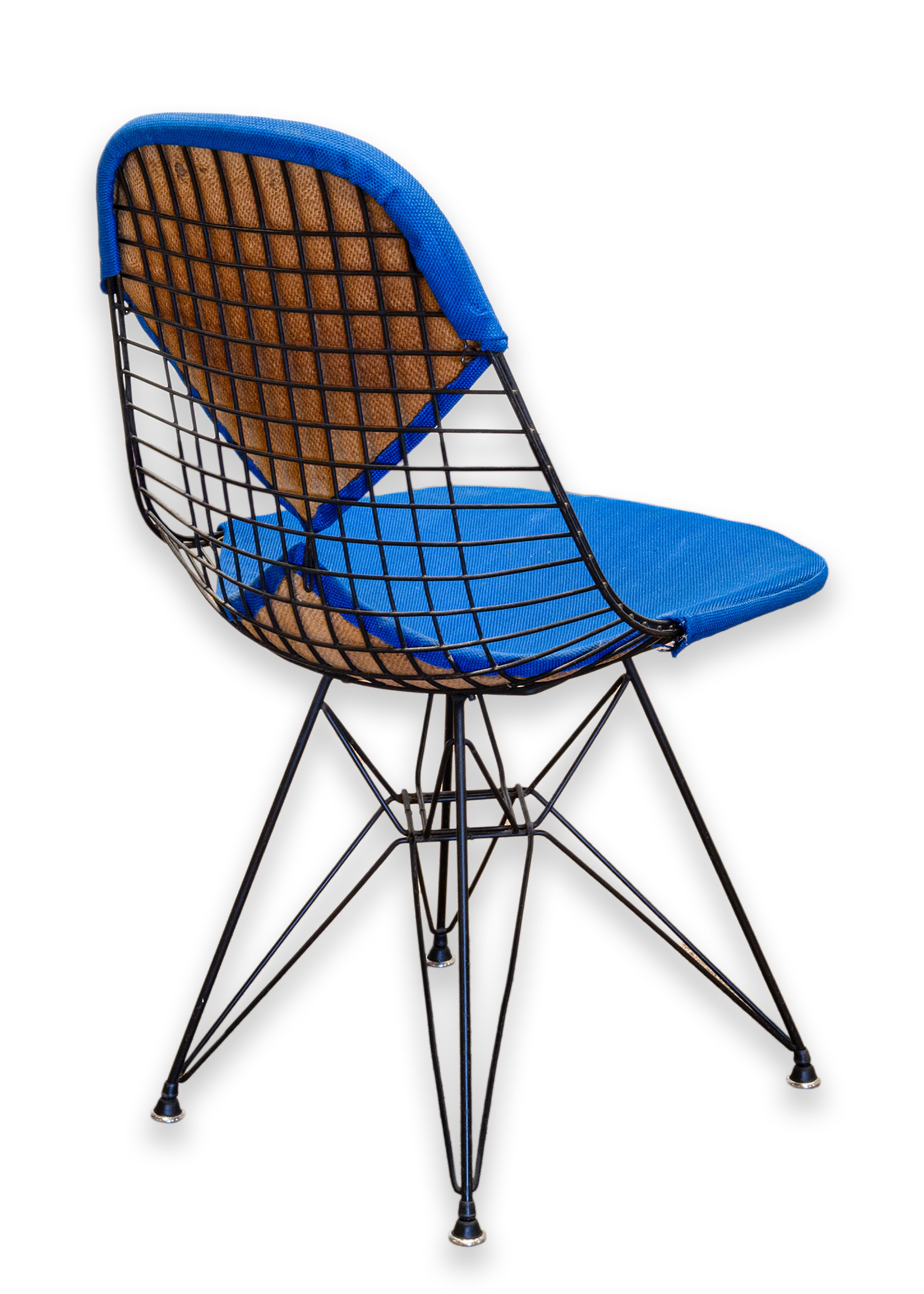 A modernist “DRK-2 Eiffel Chair” designed by Eames for Herman Miller. 1st generation, 1951. Retains the original Herman Miller, Venice, California tag on bottom of seating. Black steel base with original blue upholstery fabric in two pieces – one on