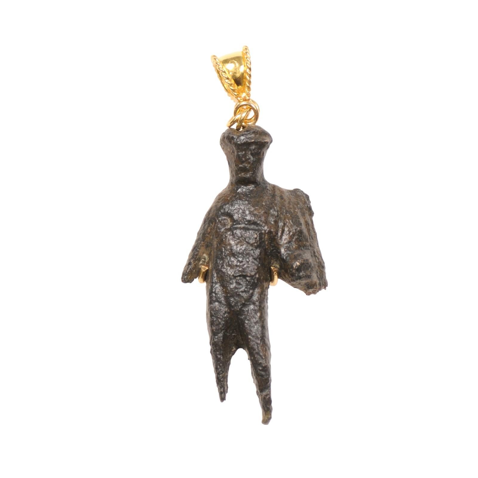 Una regale figura romana in bronzo modellata in un ciondolo con balla in oro 21k. La natura di frammento di questo pezzo è ciò che lo rende davvero unico e raro - e lo è! Questo esemplare, risalente al I e III secolo d.C., è stato creato con una
