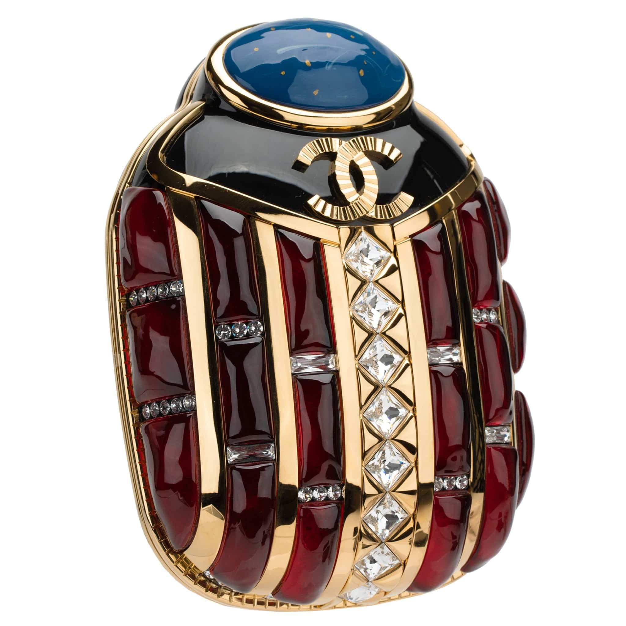 1stdibs Exclusives From Three Over Six

Brand: Chanel
Style: Egyptian Scarab Minaudière 
Size: 7.9’ x 5.5’ x 2.8’ Inch
Color: Black, Gold, Blue, Red
Material: Resin, Strass
Hardware: Gold
Year: Pre-Fall Métiers d’Art 2019

Condition: 
The product is
