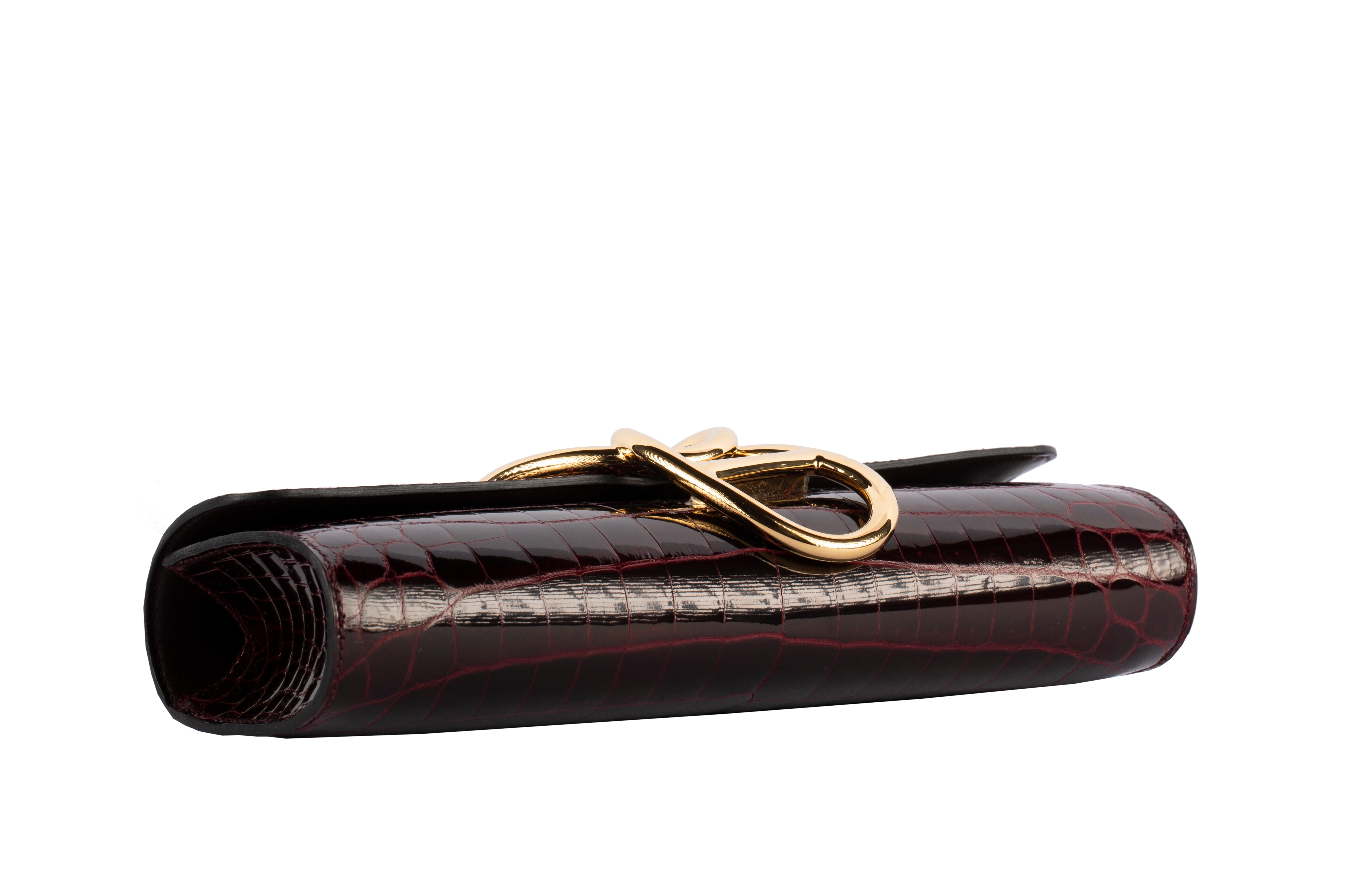 Exclusivas 1stdibs de Three Over Six

Marca: Hermès 
Estilo: Egee
Tamaño: 25,4 L x 11,43 A x 5,08 A cm
Color: Burdeos
Cuero: Niloticus brillante
Ferretería: Oro
Año: 2016 X

Estado: Prístina, nunca transportada: El artículo nunca ha sido