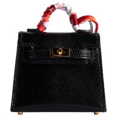 1stdibs Exclusive Hermès - Breloque Kelly en cuir de lézard noir et accessoires dorés