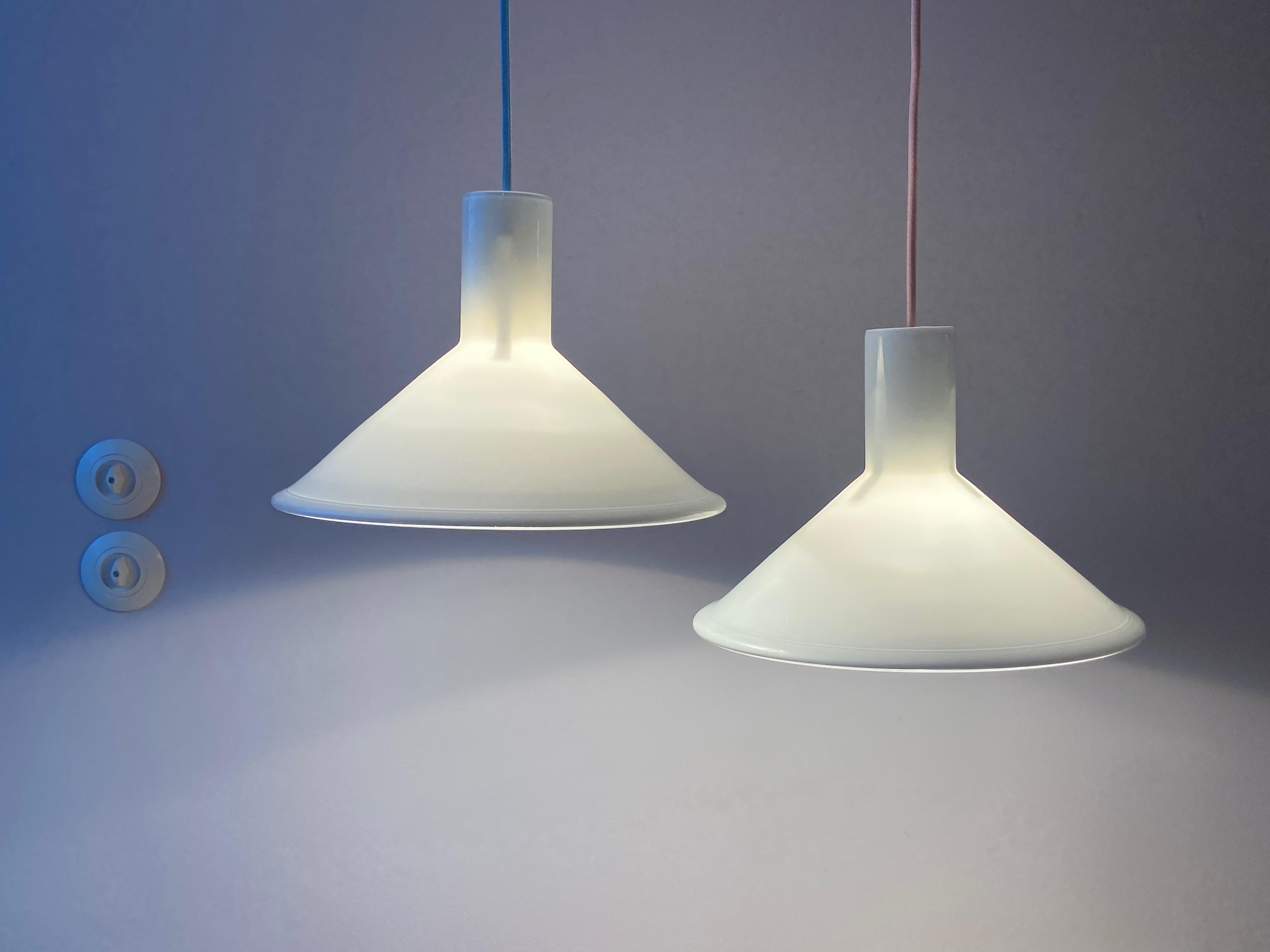 1x P&T pendant lamp designed by Michael Bang for Holmegaard in the 1970s. This Danish lamp is made of opaline glass and is white on the outside and white on the inside. The lamp is in very good condition, no damages and comes with neon yellow fabric