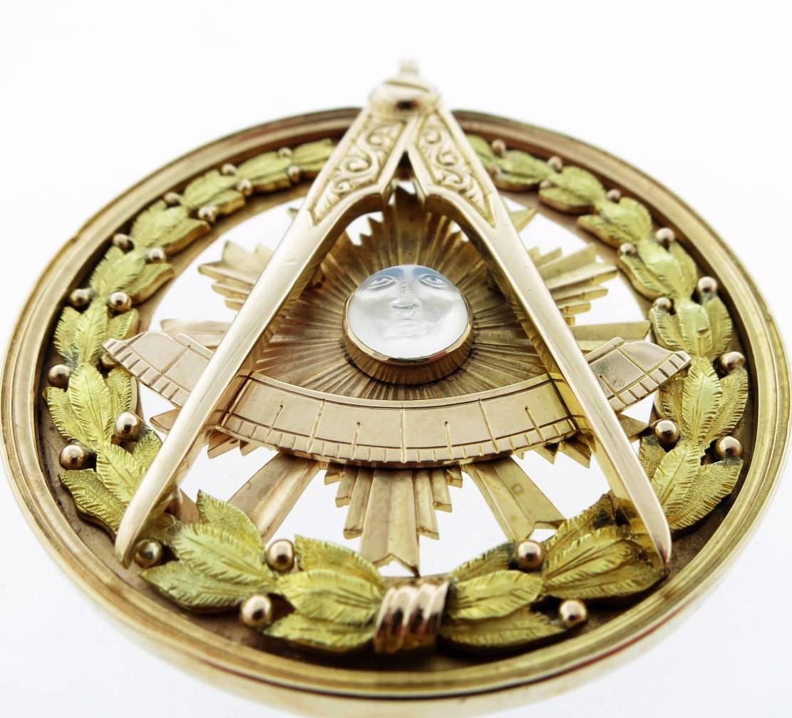 14kt. yellow, pink and green gold Freemason symbol with square and compass with a barley twist motif frame, beautifully made with a carved moonstone center. The pendant measures 2 1/4 inches and weighs 34.1 gr. Excellent condition !