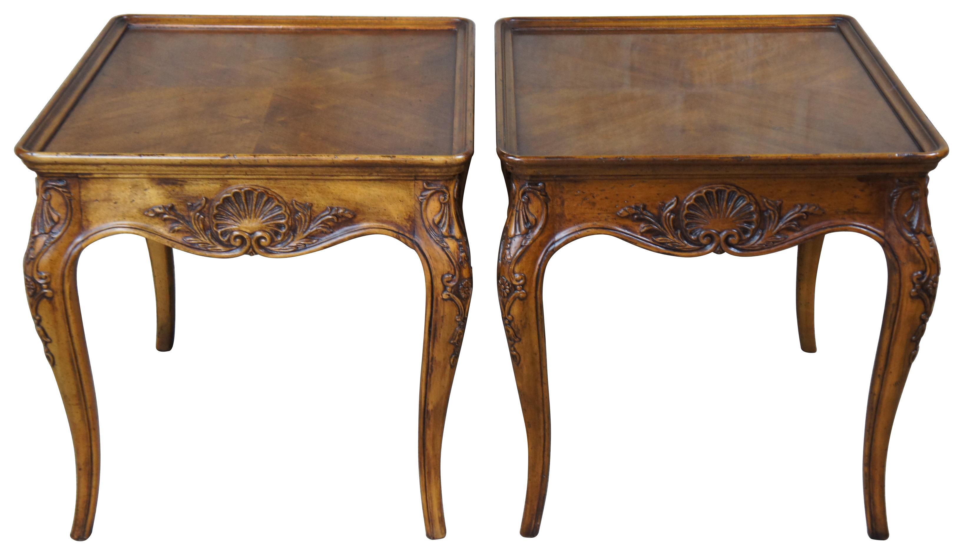 Pair of Henredon French Country side tables, circa 1987. Made from Walnut with an inset bookmatched walnut top over a carved and scalloped arpon. The tables are supported by cabriole legs with shell and cartouche carvings. Style No 3201-41.
  