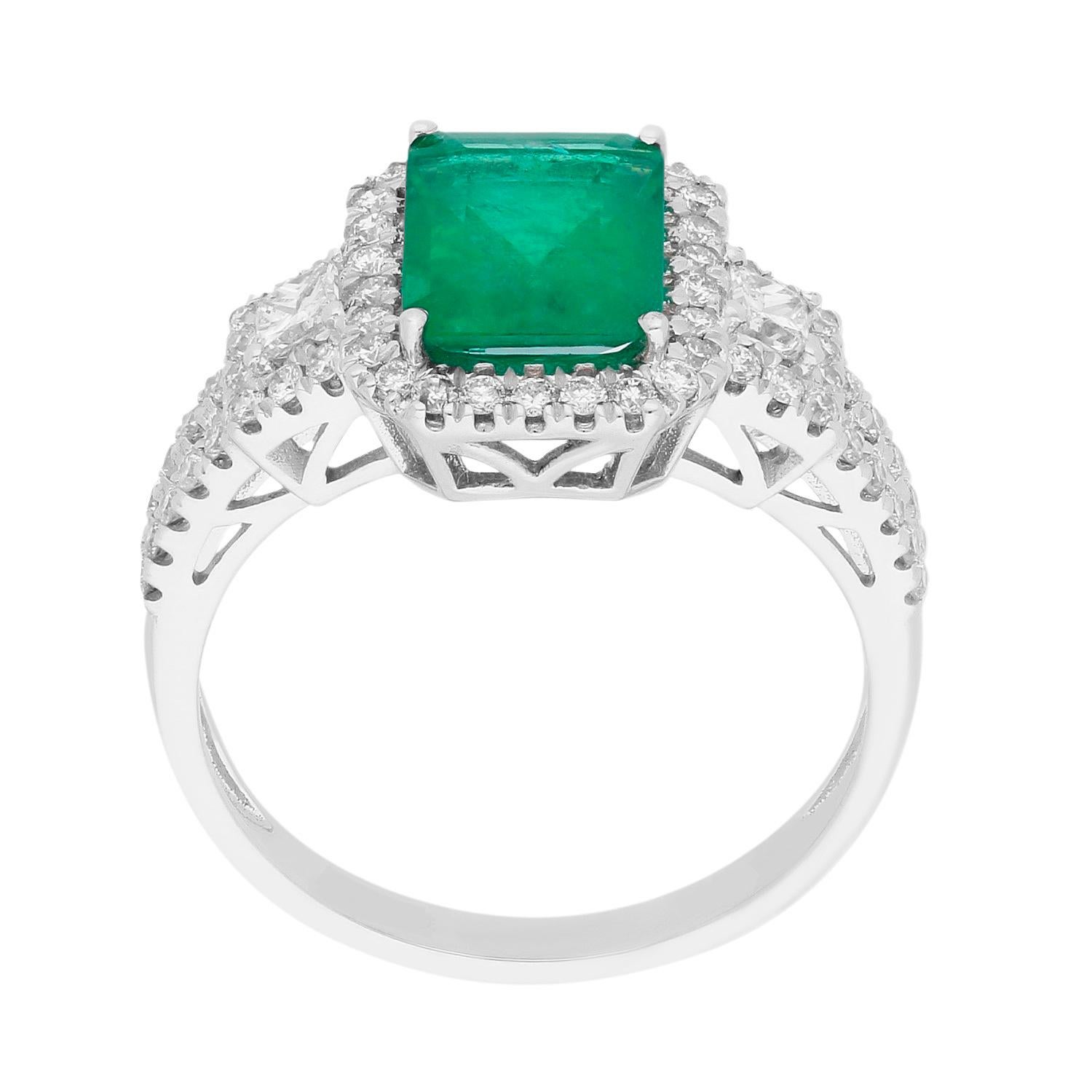 This beautiful Engagement ring is crafted in 18-karat White gold and features a 2 2/5 Carat Emerald, 62 Round 2/5 ct. brilliant cut diamonds , 2 pc. Square princess-cut 1/6 ct. diamond in a prong-setting. 
This ring is a perfect gift either for