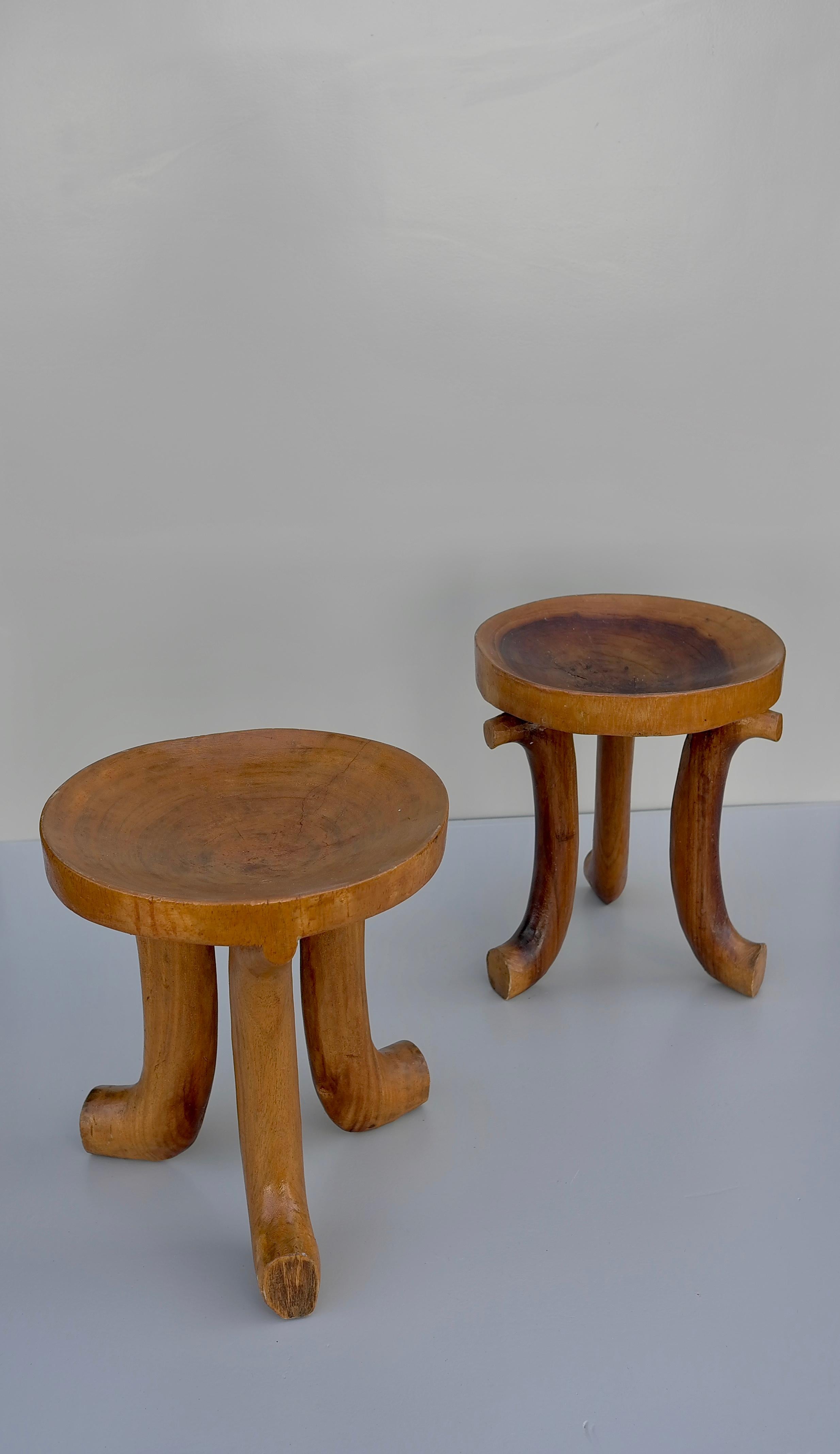 A wonderfully pair of sculptural early 20th century Ethiopian Gurage Stools carved of one piece of wood showing a hand carved texture, with three curved legs supporting a convex bowl-form seat with a beautiful patina.