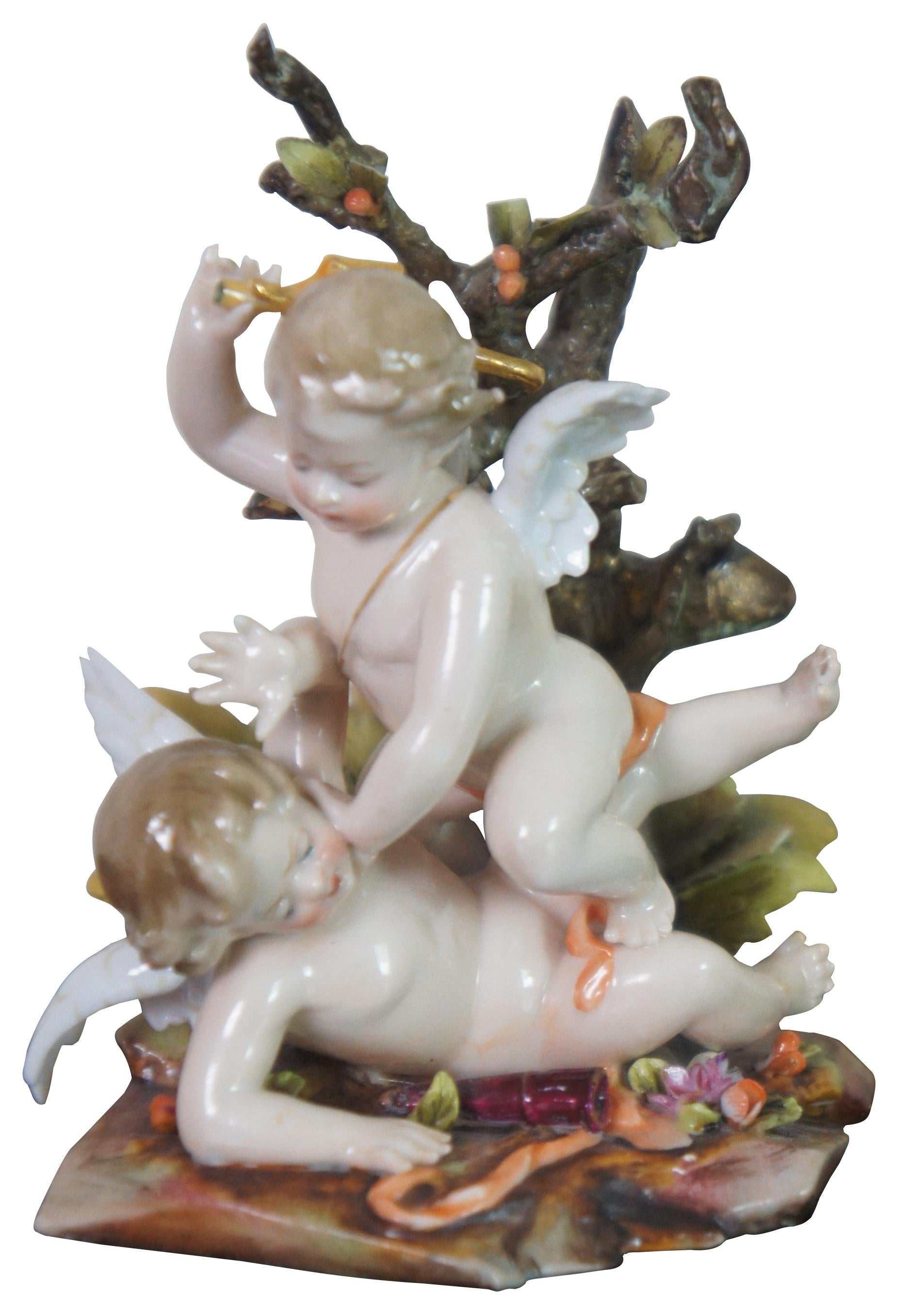 Pair of two rare early 20th century German Volkstedter porcelain figurines showing pairs of cherubs / angels / putti / cupids tumbling among rocks and trees, made by Richard Eckert in Volkstedt around 1905. This factory was affiliated to the oldest