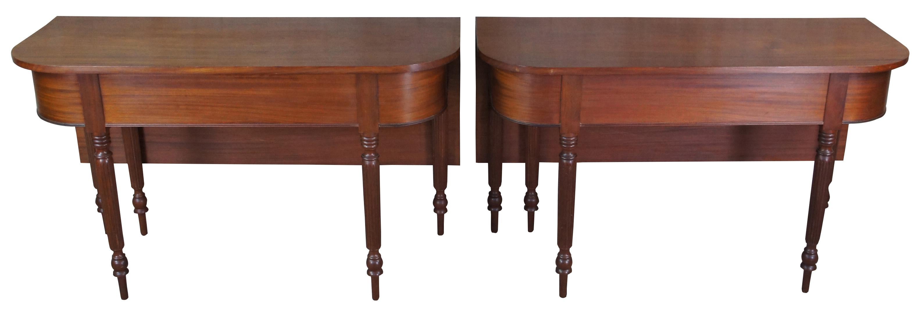 A fine and exquisite pair of antique 19th Century Sheraton banqueting tables, circa 1810s. Made of solid mahogany featuring demilune form with gate leg or large drop leaf that swings out via a hand carved wooden hinge. The tables are supported by