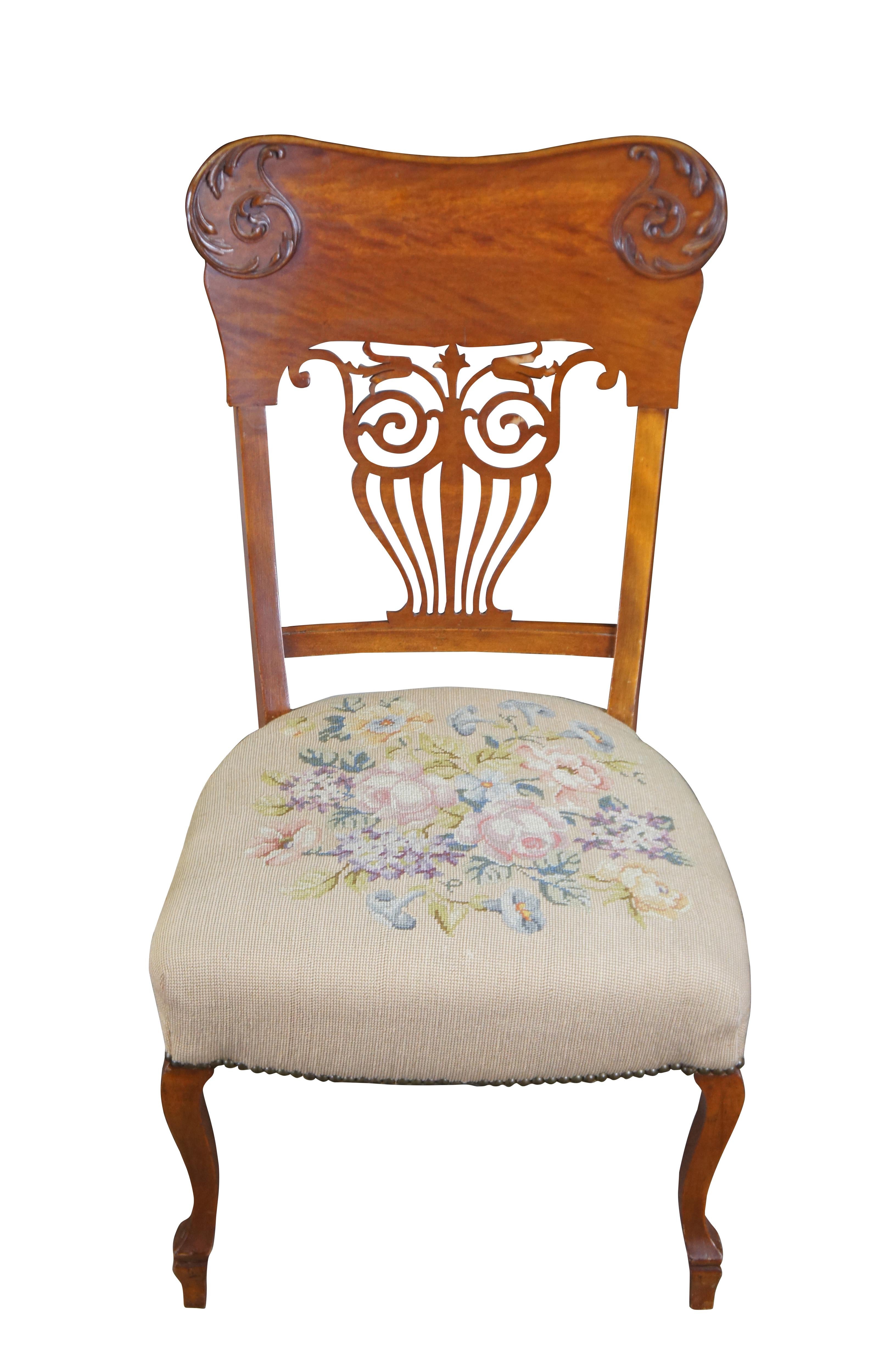 2 ornate late Victorian chairs. Made from quartersawn oak with a countoured back featuring applied and scrolled foliate over a pierced splat back. The seats are embroidered with rose pattern. The chairs are supported by cabriole legs over peg