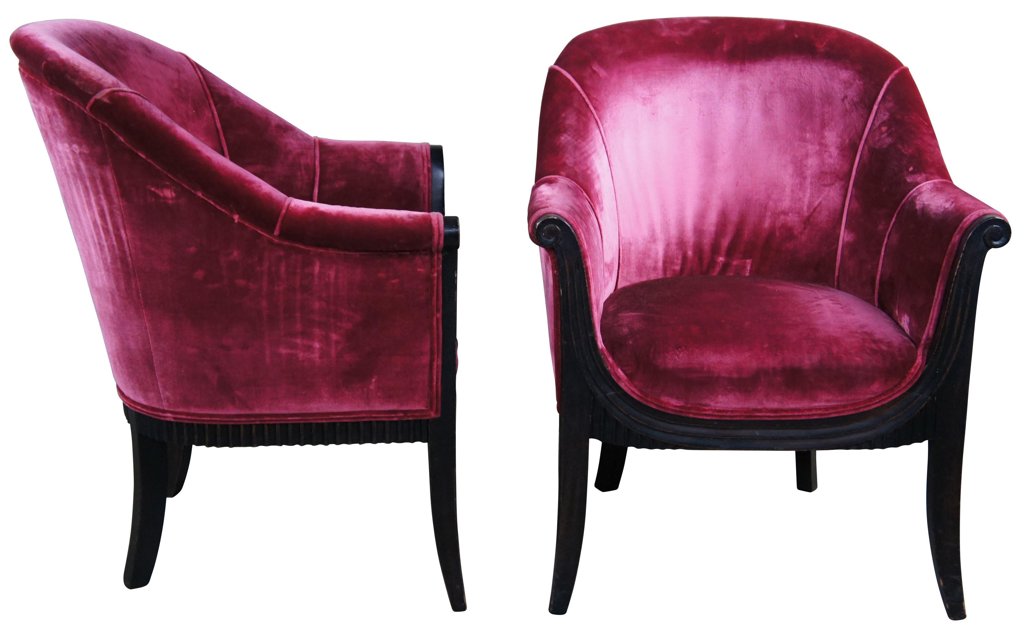 Pair of late Art Deco arm chairs. Made from mahogany with an ebonized frame featuring flared and scrolled arms, pink velvet fabric and a ribbed apron. A nice compliment to your library or living space. Measure: 36