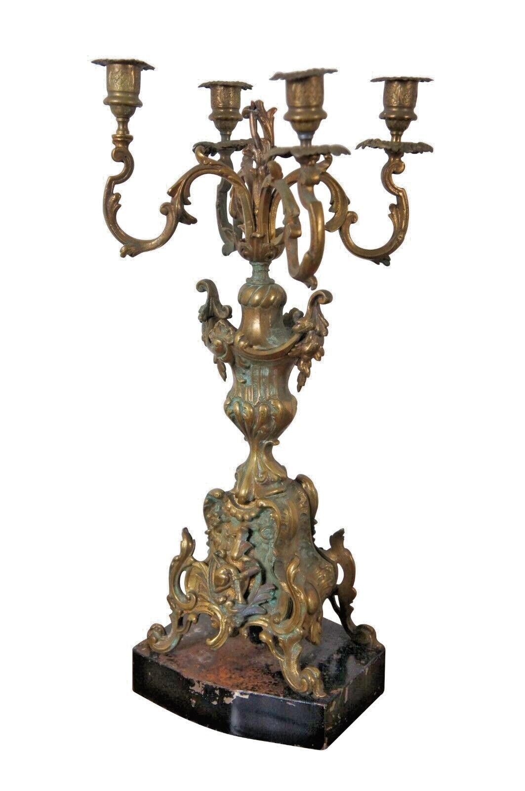 Pair of antique bronze baroque style four arm candelabras, mounted on black painted metal bases and partially converted for electrics.

Dimensions:
10