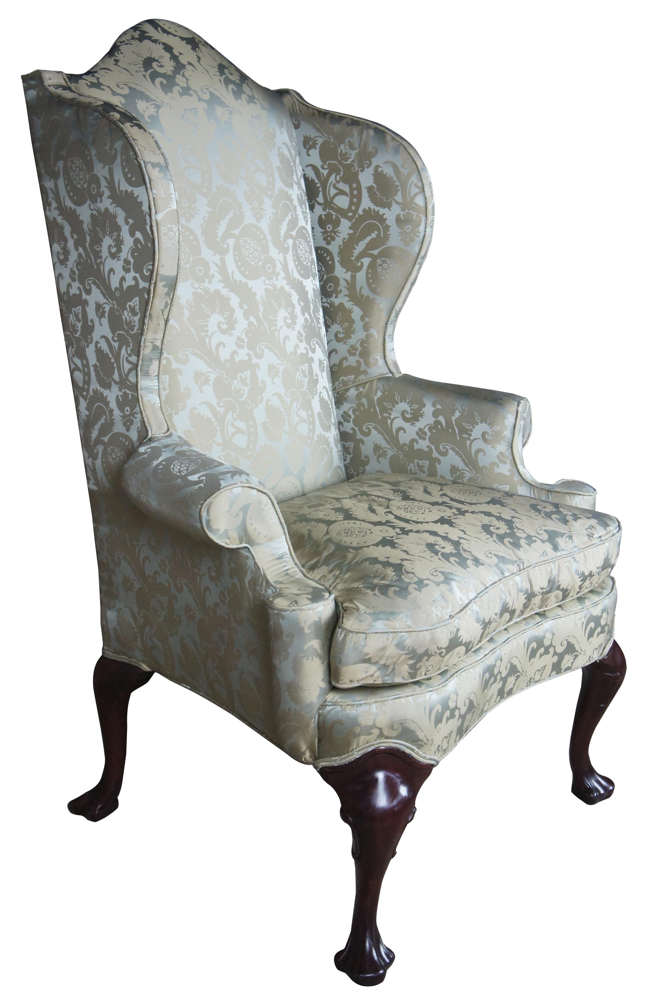 2 Antique Queen Anne Mahogany Wingback Arm Chairs Chippendale Damask Fabric

Queen Anne inspired wing-back armchair duo with Damask upholstery and cabriole legs in mahogany that lead to a trifid foot. 
