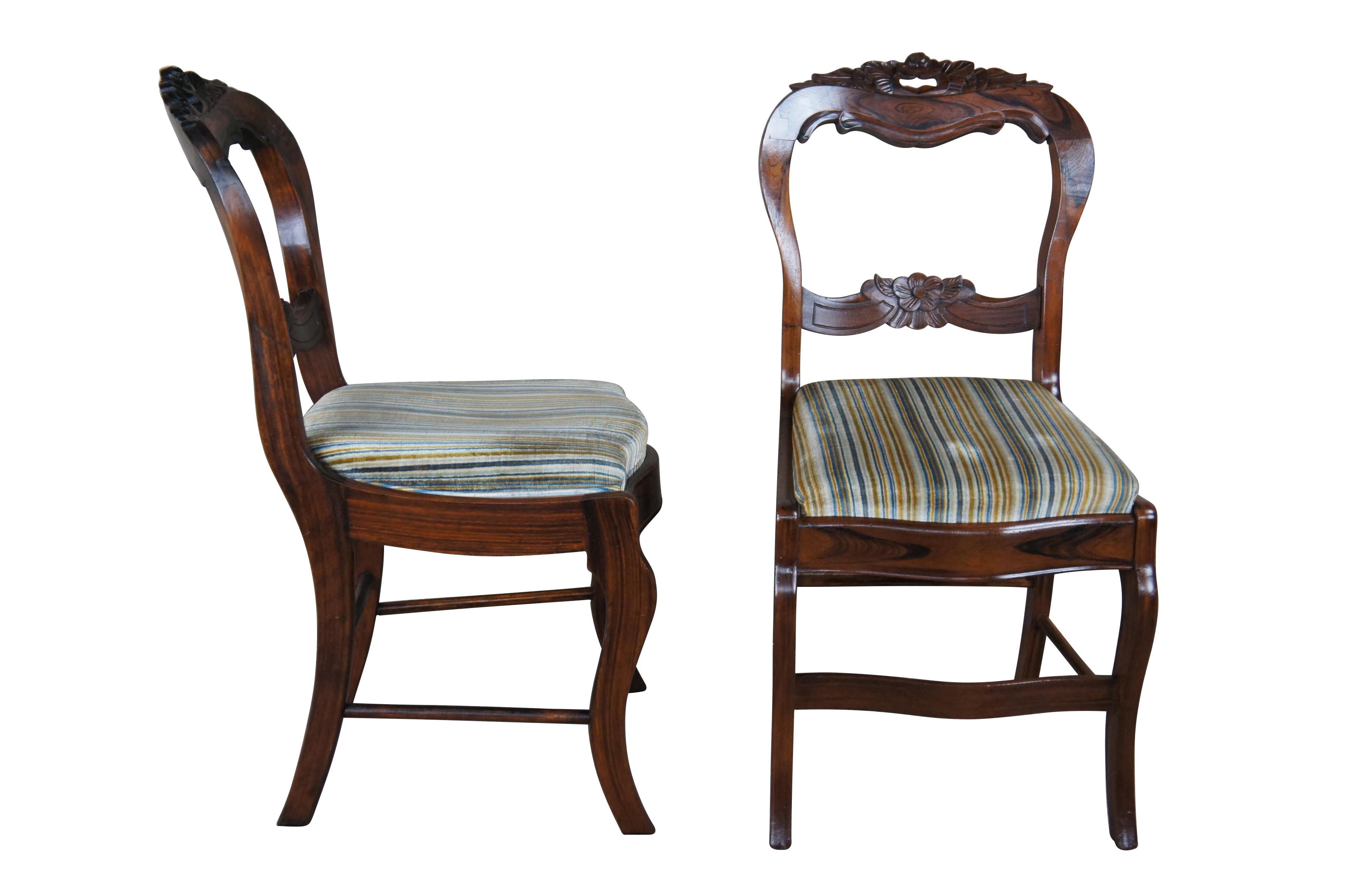 Two antique Duncan Phyfe / Balloon back style dining chairs.  Made of rosewood featuring serpentine form with carved floral accents and striped upholstery.

Dimensions: 
17