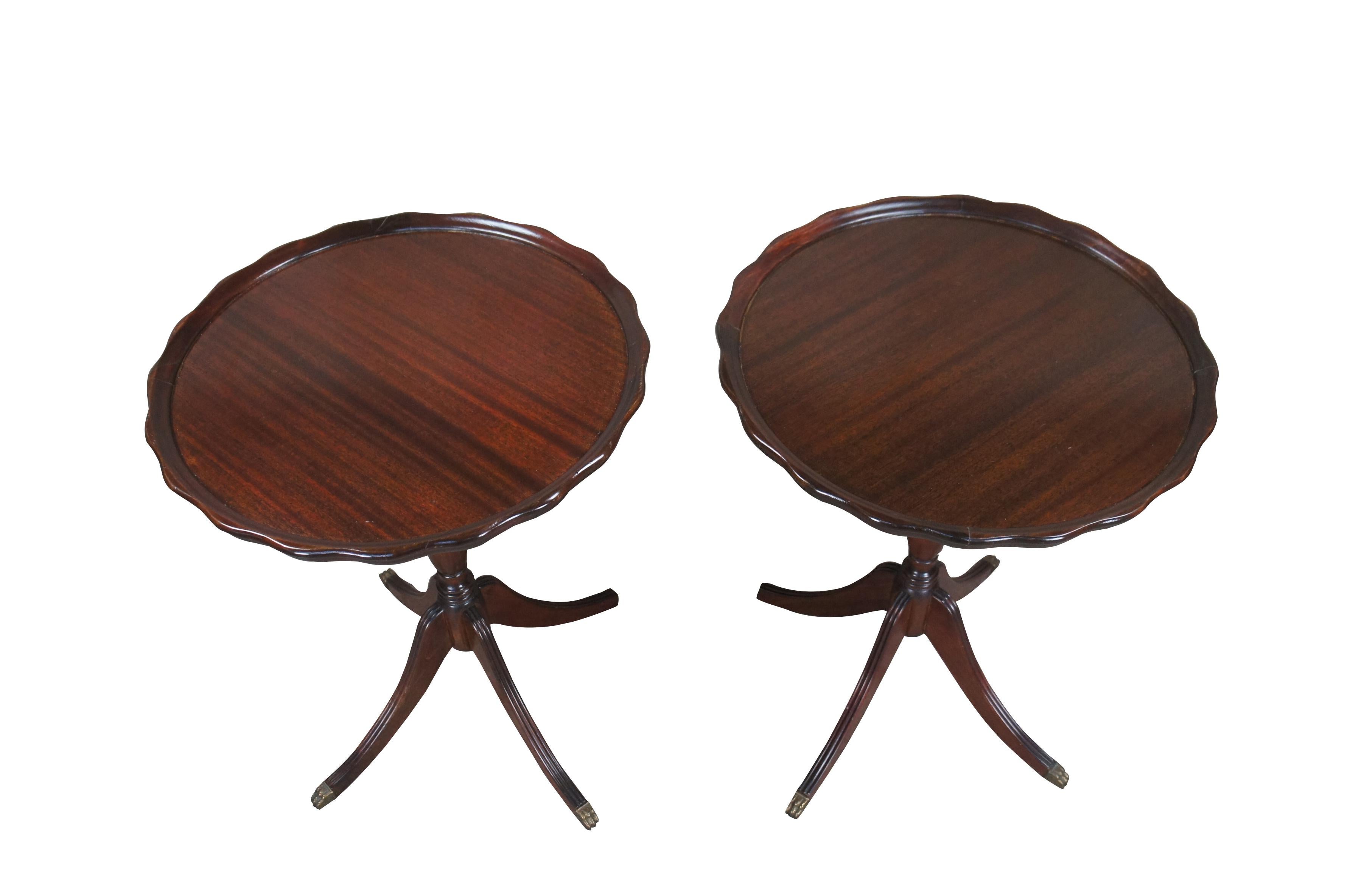 1940s Duncan Phyfe style pie crust tables.  Made from mahogany with an inset scalloped top over a turned support with downswept fluted Duncan Phyfe legs and brass capped paw feet. 

Dimensions:
22