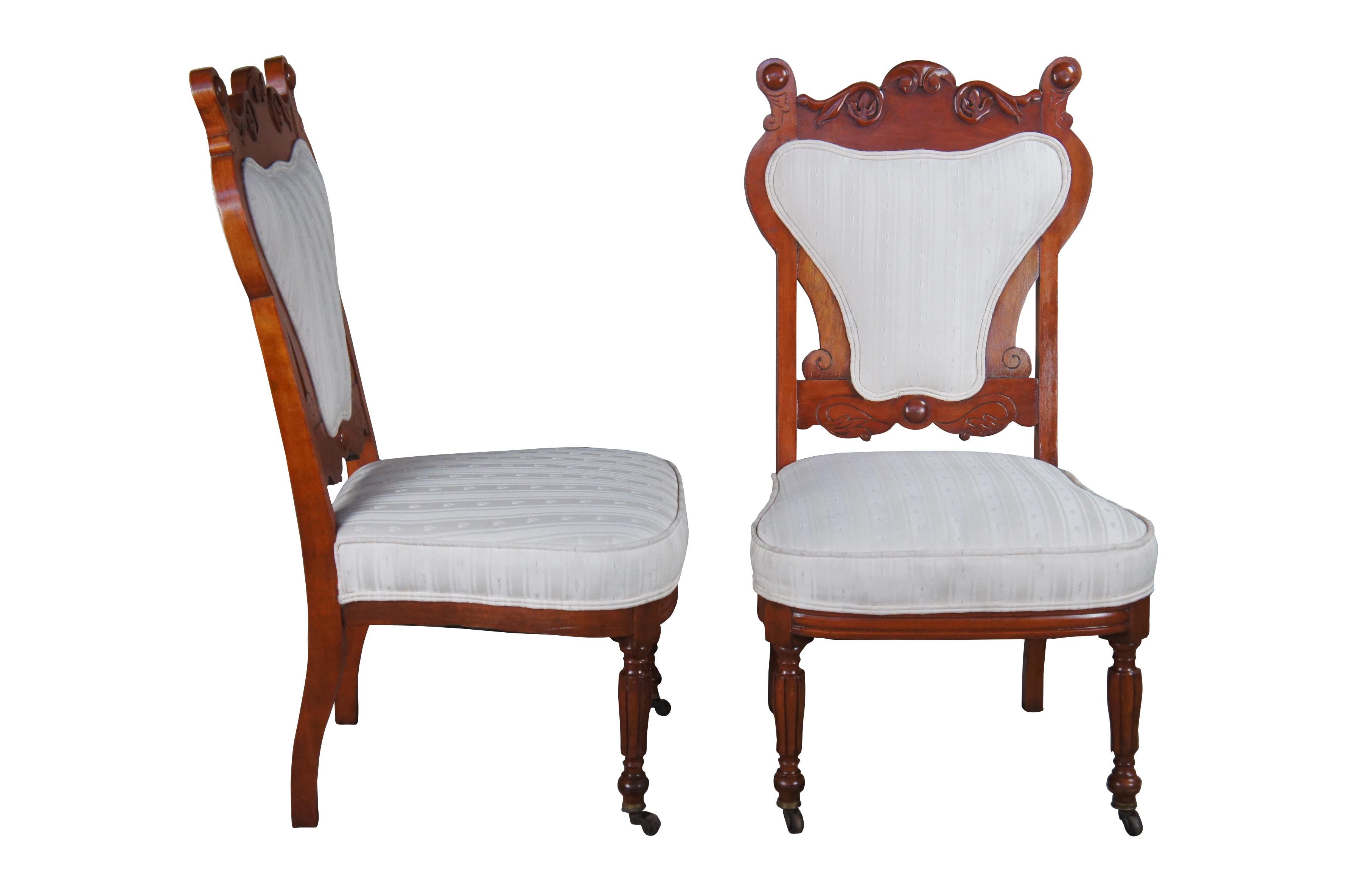 Two antique Edwardian / Victorian parlor dining chairs.  Made of mahogany featuring Art Nouveau styling with a very unique heart shaped back with carved foliate design at the crest, flanked by half ball finials over pierced center, supported by
