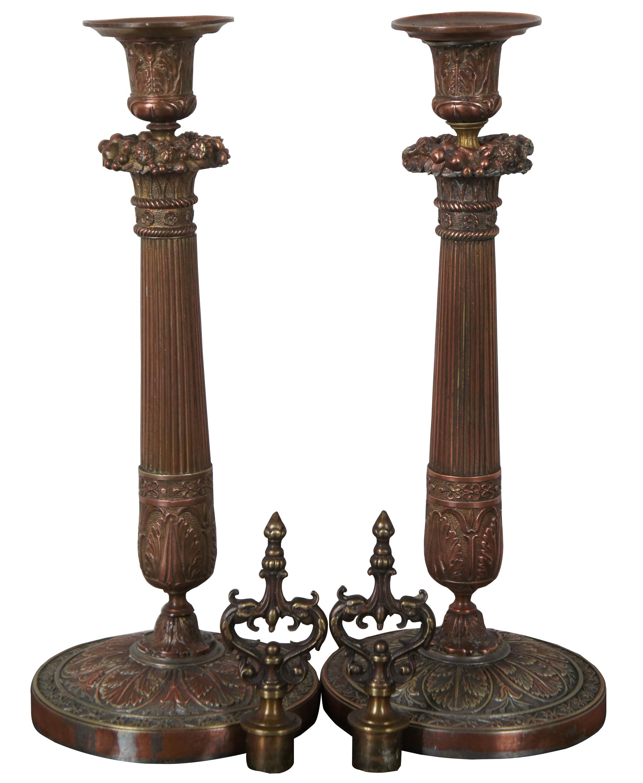 Pair of gilt bronze candlesticks in the manner of the French Restauration period, decorated with seeds, foliage and flowers on a round base ornamented with grape vines.

Measures: 13”, height with drip catcher 12.75”, height with finial 16.5”.