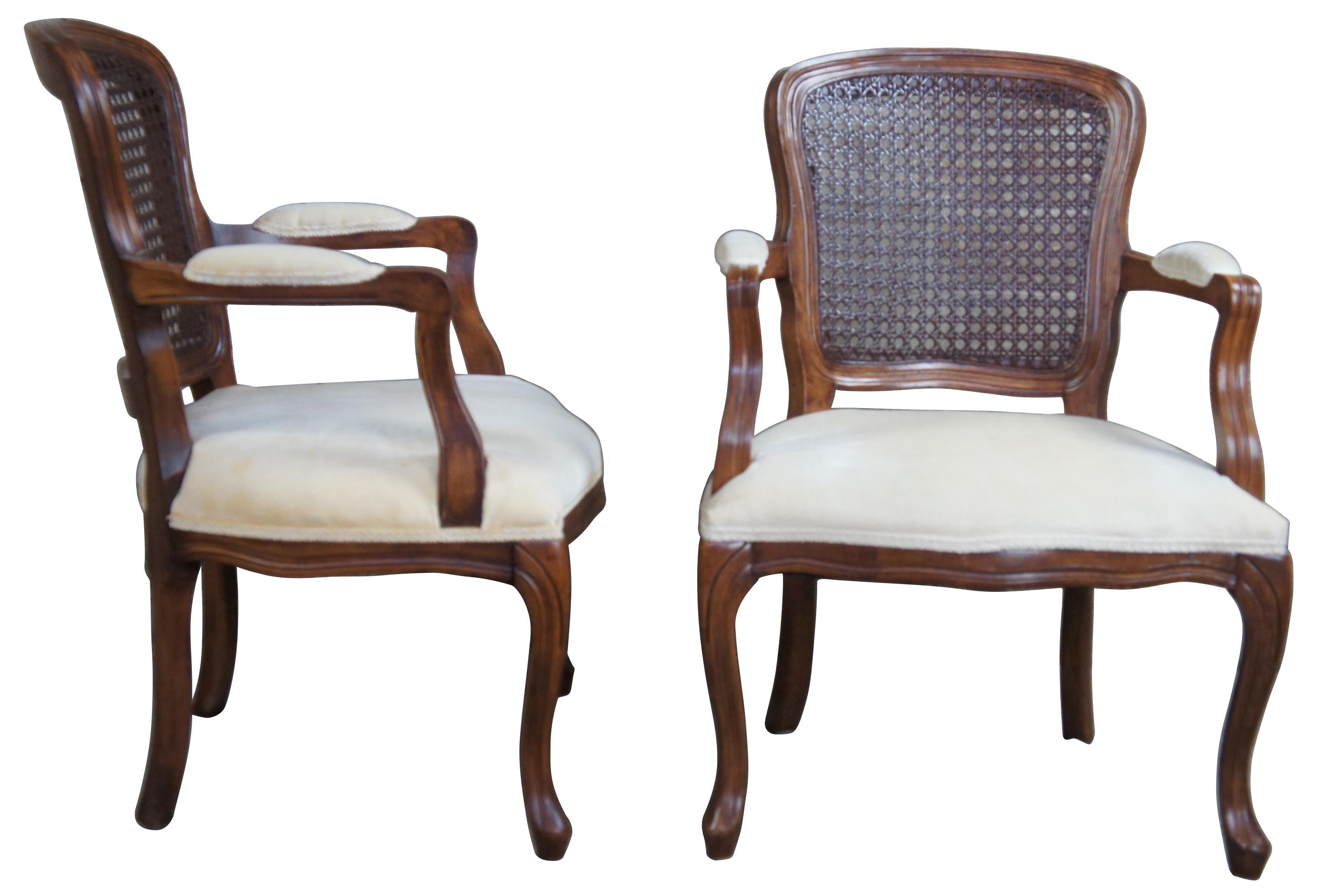 Antique distressed walnut cane back chairs. Features open arms and cabriole legs. 
  