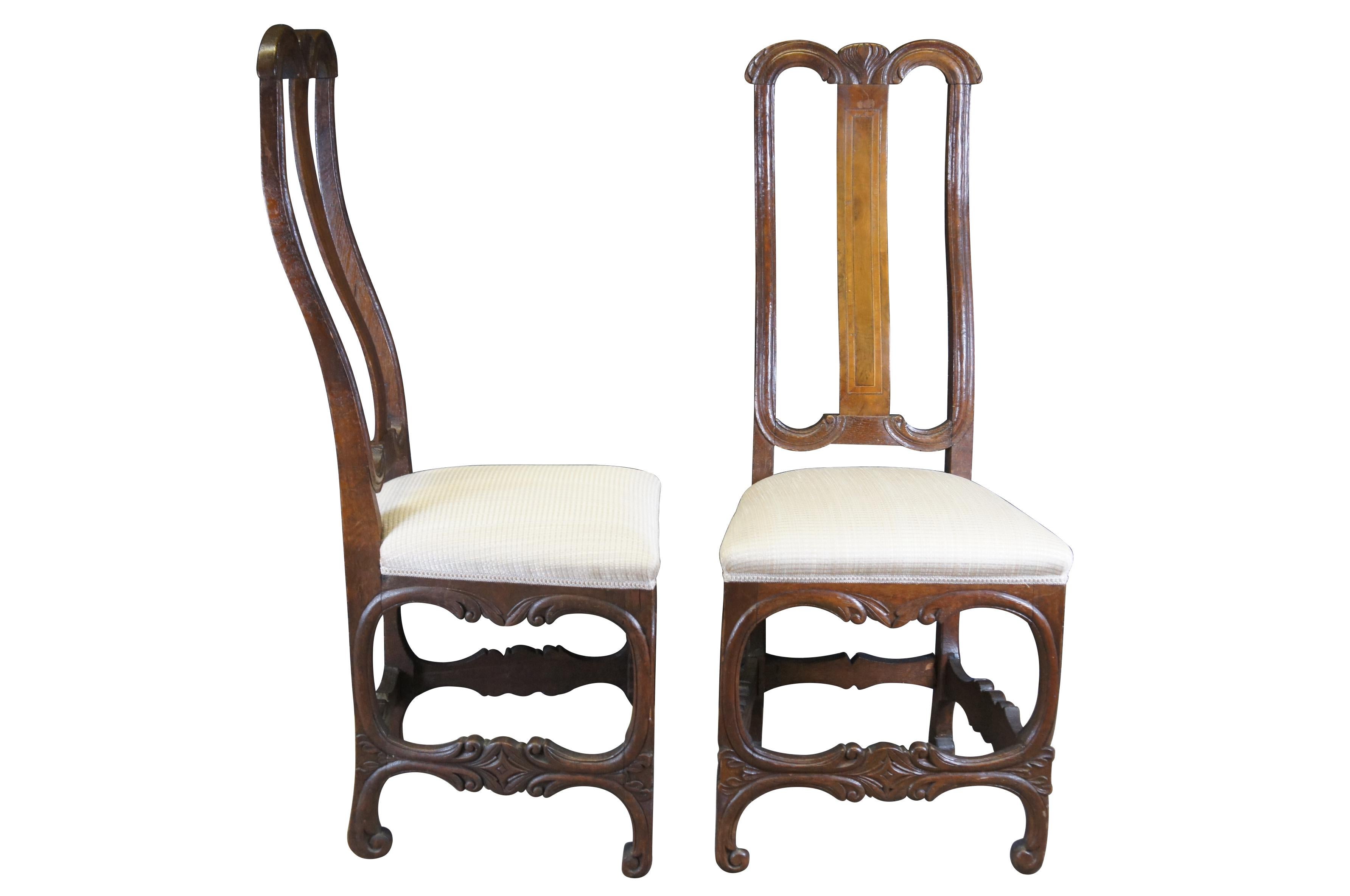 Two antique 19th century German dining side chairs.  Made of mahogany featuring baroque form with inlaid accents and unique serpentine carved stretchers.  Shipping label on bottom reads Heinrich Klingenberg, Hamburg Germany.

Heinrich Klingenberg