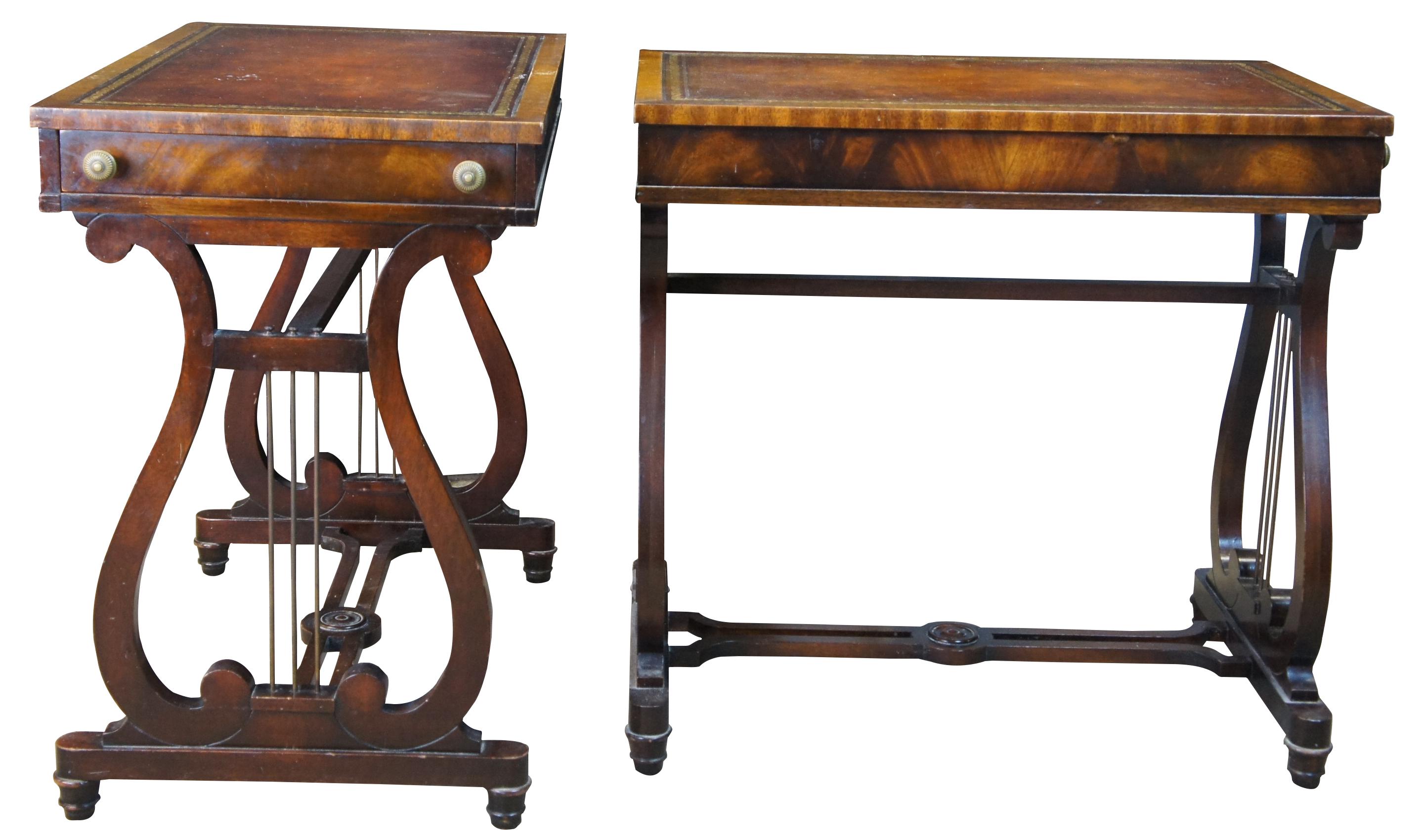 An elegant pair of Heirloom Weiman end tables, circa 1930s. Features a rectangular top with tooled leather top and drawer over a lyre shaped base. Made from mahogany with flame mahogany apron and drawer front. #9405.