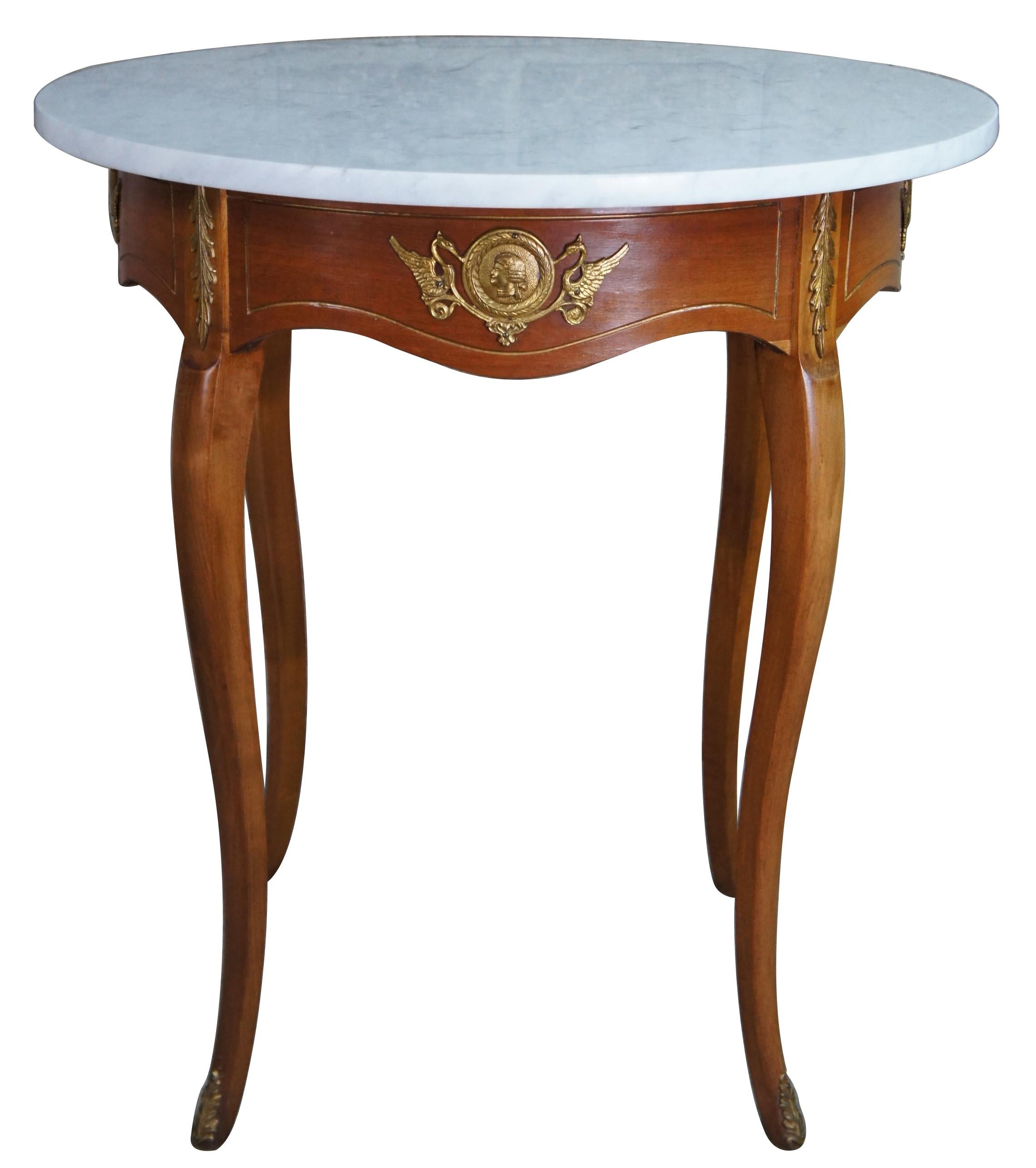 Two antique Italian Neoclassical Gueridon tables. Made of fruitwood with gold medallions that feature a bust of a mans head surrounded by a wreath flanked by swans / birds. Accanthus accents and feet caps adorn the serpentine legs. Original marble