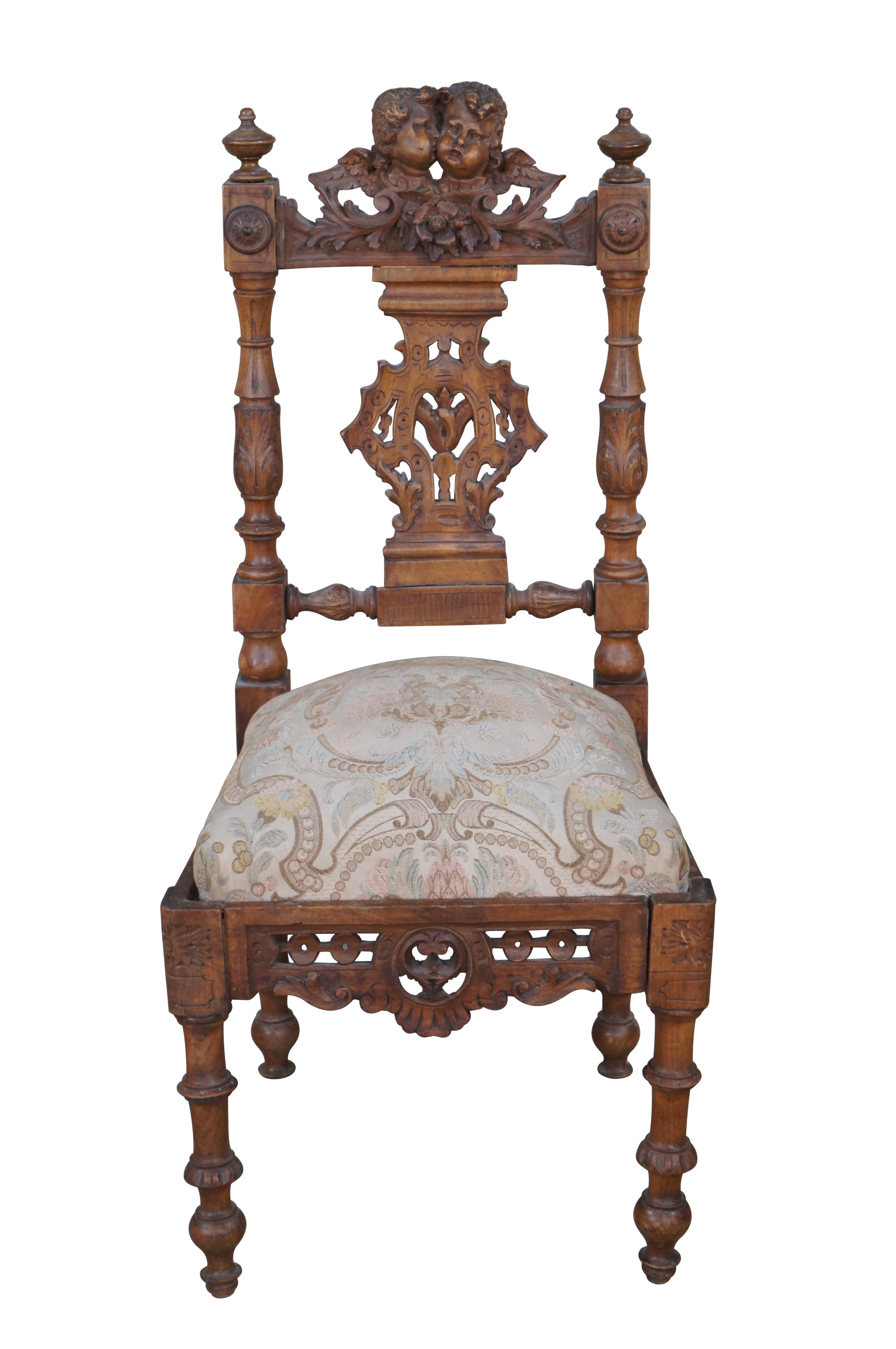 Pair of Antique Italian Neo-Renaissance side chairs, circa 1870s. Made of walnut featuring Neoclassical styling with high relief figural carvings of cherubs /puttis over pierced foliate back splats and acanthus turned posts.  The chairs showcase a