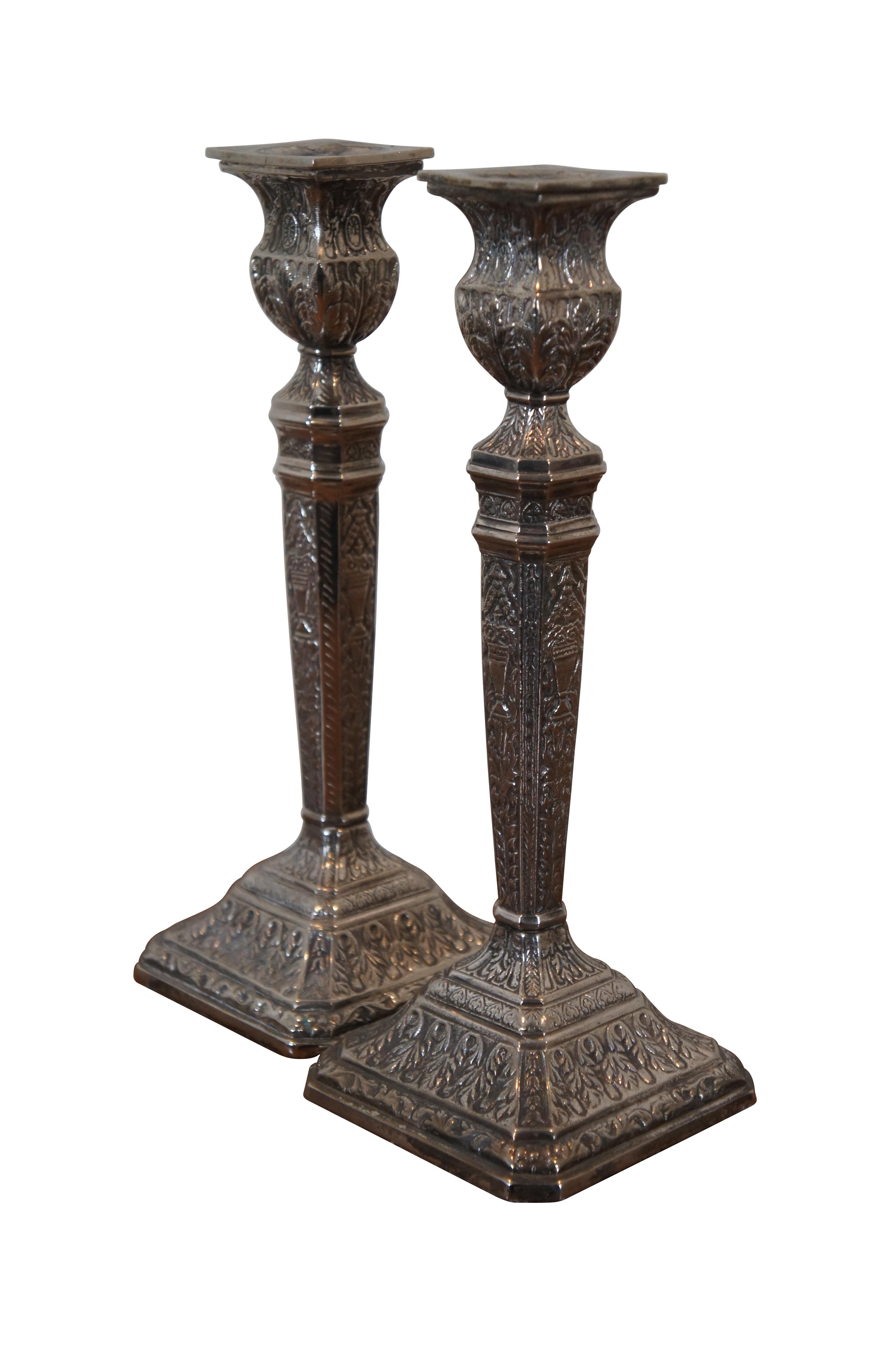 Pair of heavy, antique Georgian style repousse silver plate candlesticks / taper candle holders. Square cut corner base and tapered column with planter-urn shaped top, ornately decorated with swags of foliage, flowers and Neoclassical vases. Bottom