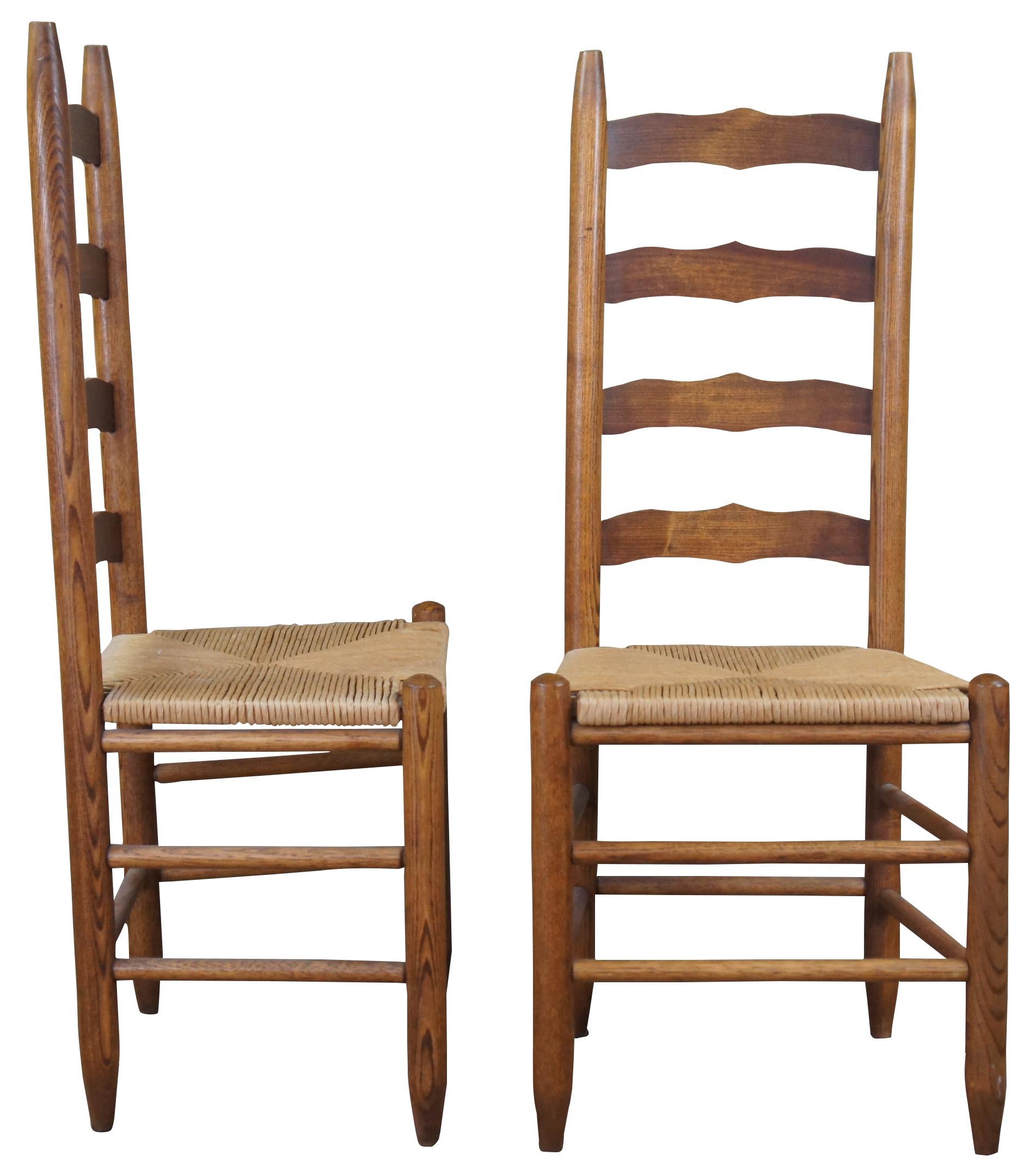 Pair of two antique ladder back side dining chairs. Made of oak featuring woven rush seats and tall ladderback with serpentine form.