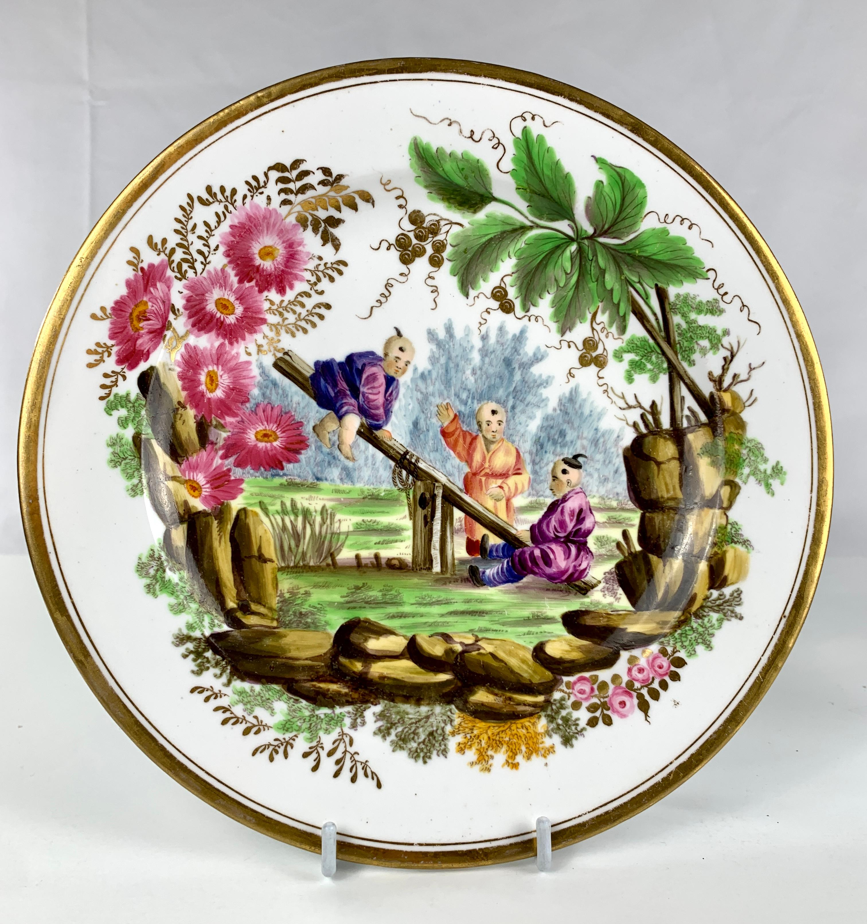 These two Minton porcelain dishes are exceptional masterpieces of the ceramic art form. The chinoiserie scenes, painted by hand, exhibit intricate details, vibrant colors, and a playful spirit. One dish features a young boy running in a field, while