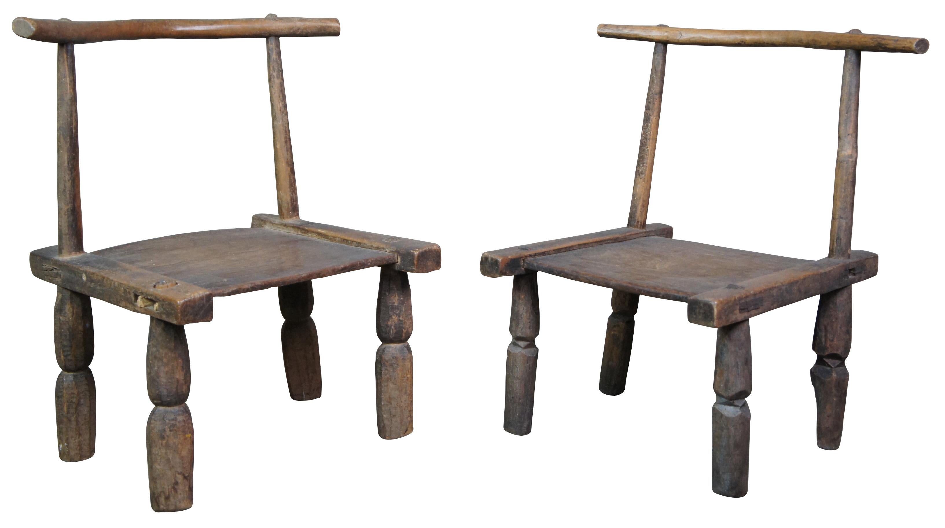 Two primitive carved African Baule chairs. Made from indigenous local woods featuring yoke back, short legs and flat seat.

These low chairs were carried on the shoulders of village men as they went to attend social gatherings or community