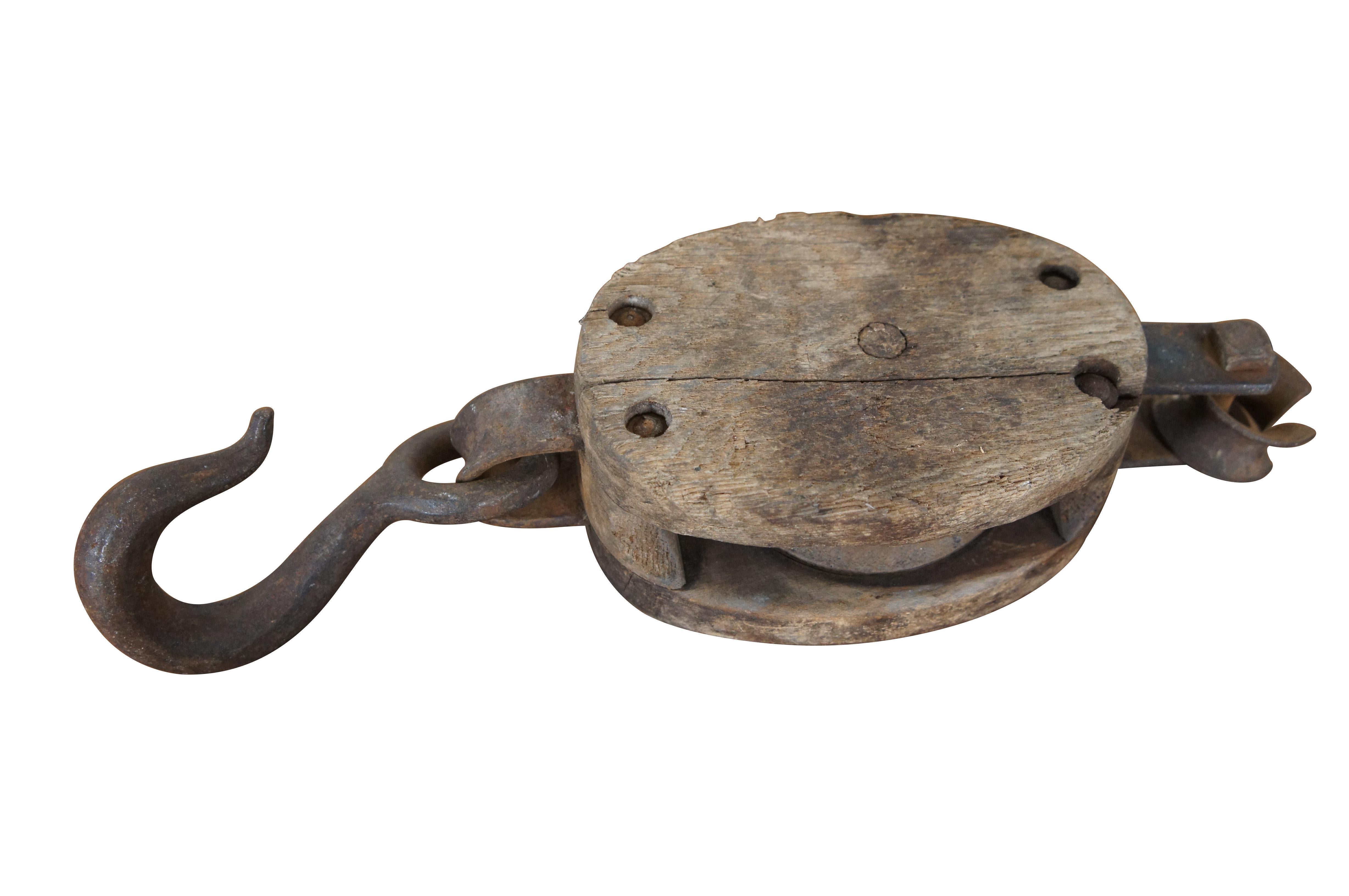 Two primitive antique iron and wood pulley hoist hooks, one by Starline.  Rustic, nautical, industrial, farmhouse, cabin decor.


DIMENSIONS:
Large - 4.25” x 2.75” x 13.75” / Small - 3.75” x 2.75” x 12” (Width x Depth x Height)
