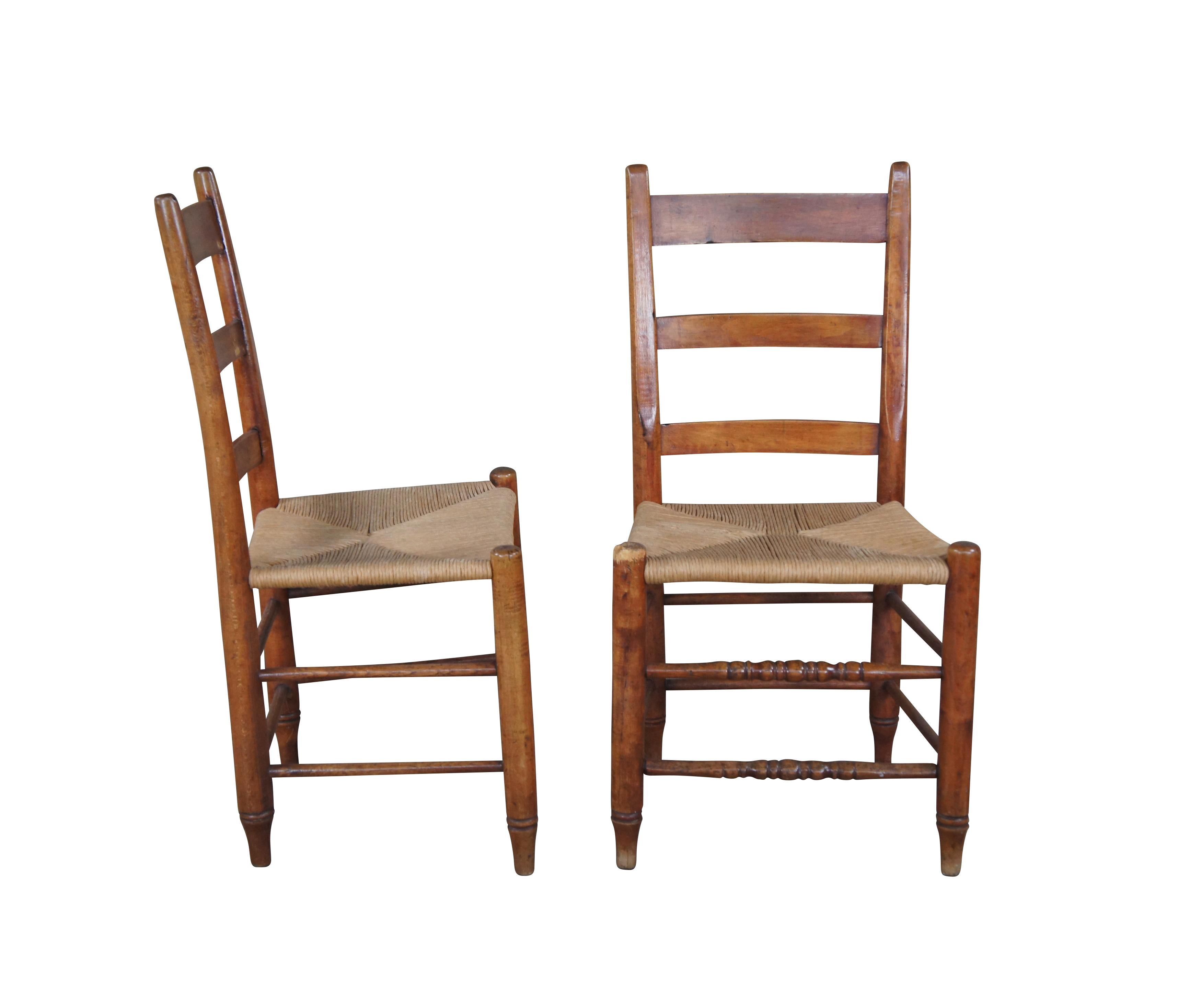 Two primitive antique ladderback chairs. Made of maple featuring turned supports, with rush seat and ladder back.

Dimensions:
18