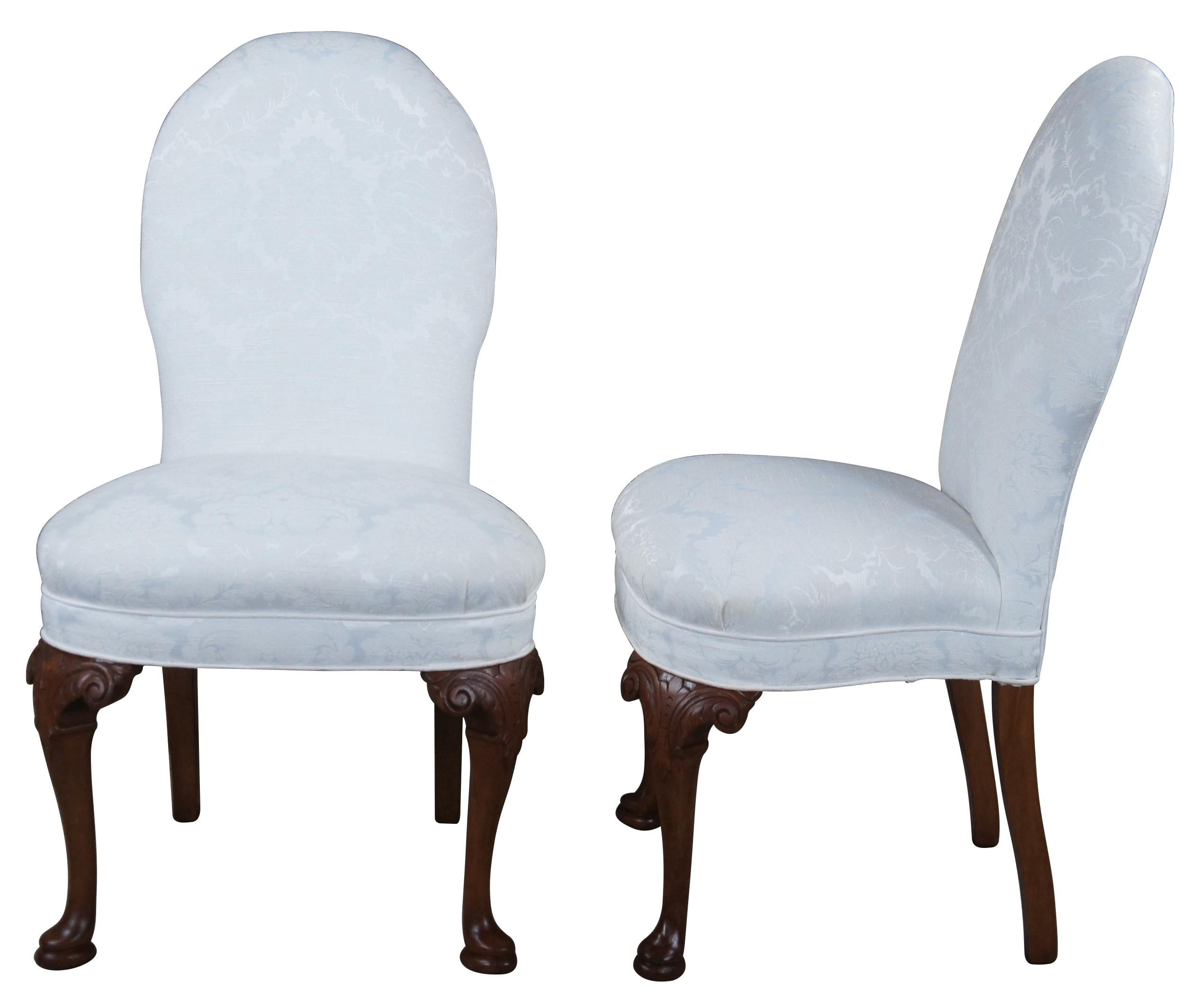 Beautiful pair of Queen Anne style side chairs. Reminiscent of the classic spoon back chairs from the Victorian era. Made from mahogany with acanthus carved and scrolled knees leading to cabriole legs and pad feet. The chairs are upholstered in a