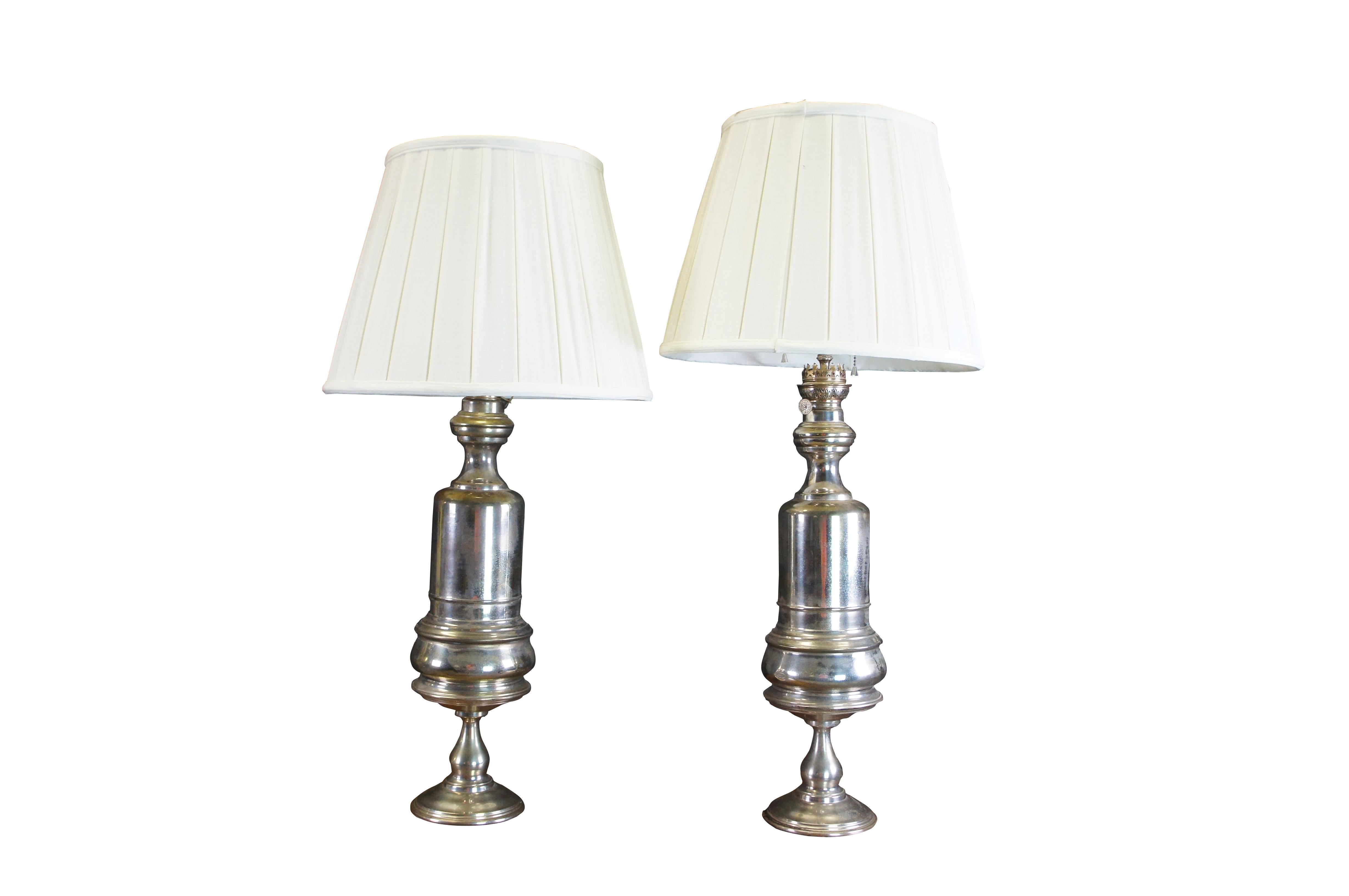 Deux lampes à huile / lanternes / lampes de table victoriennes converties en argent plaqué, présentant une forme de trophée ou d'urne de cheminée avec deux chaînes de traction, une base à pied et des abat-jour orientaux.

Dimensions :
31