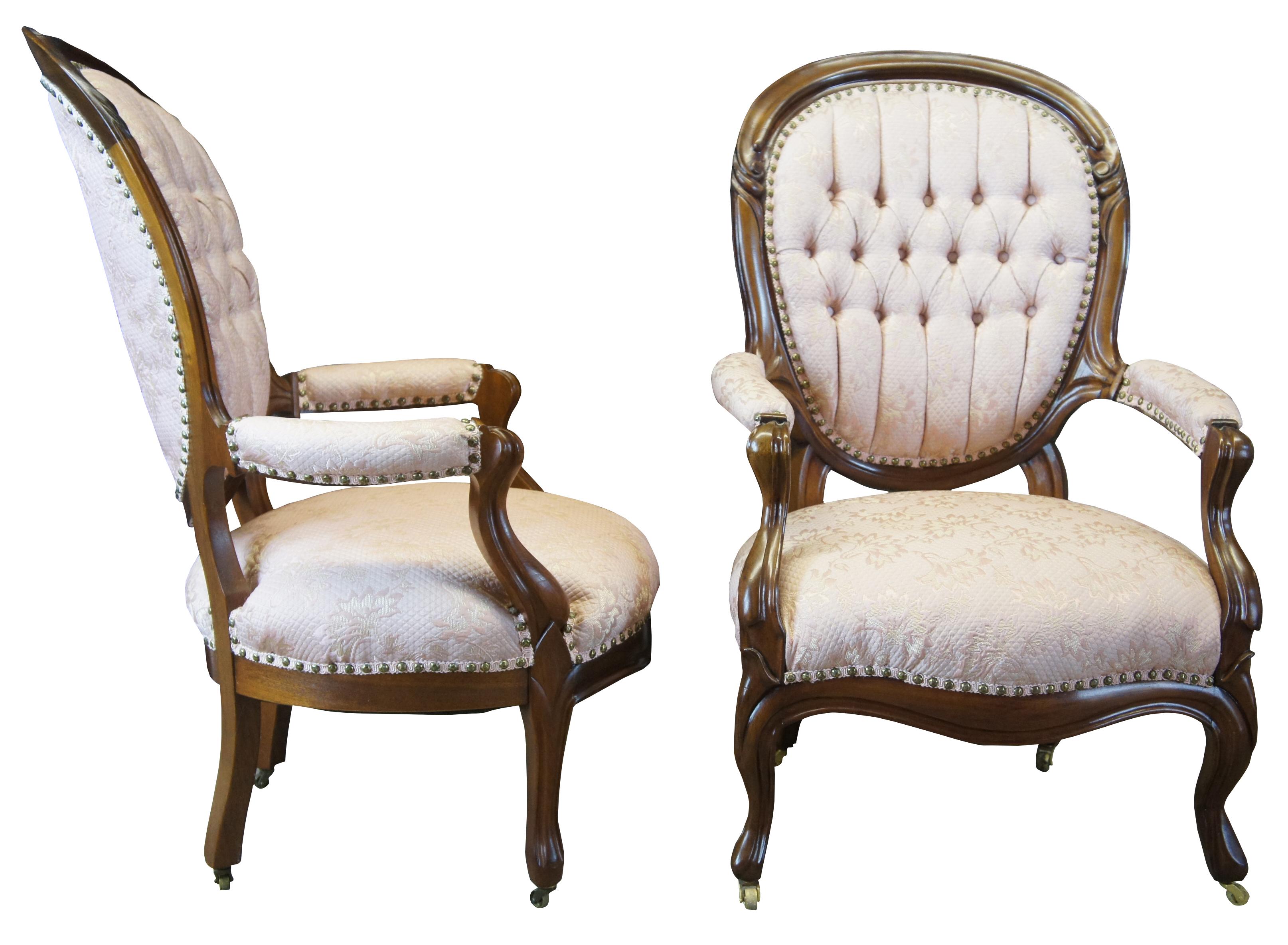 Pair of two antique Victorian his and hers parlor arm chairs. Made of walnut featuring serpentine form with blush pink floral upholstery, tufted balloon backs, padded arms, nailhead trim, and brass swivel castors.

Measures: his 26.5