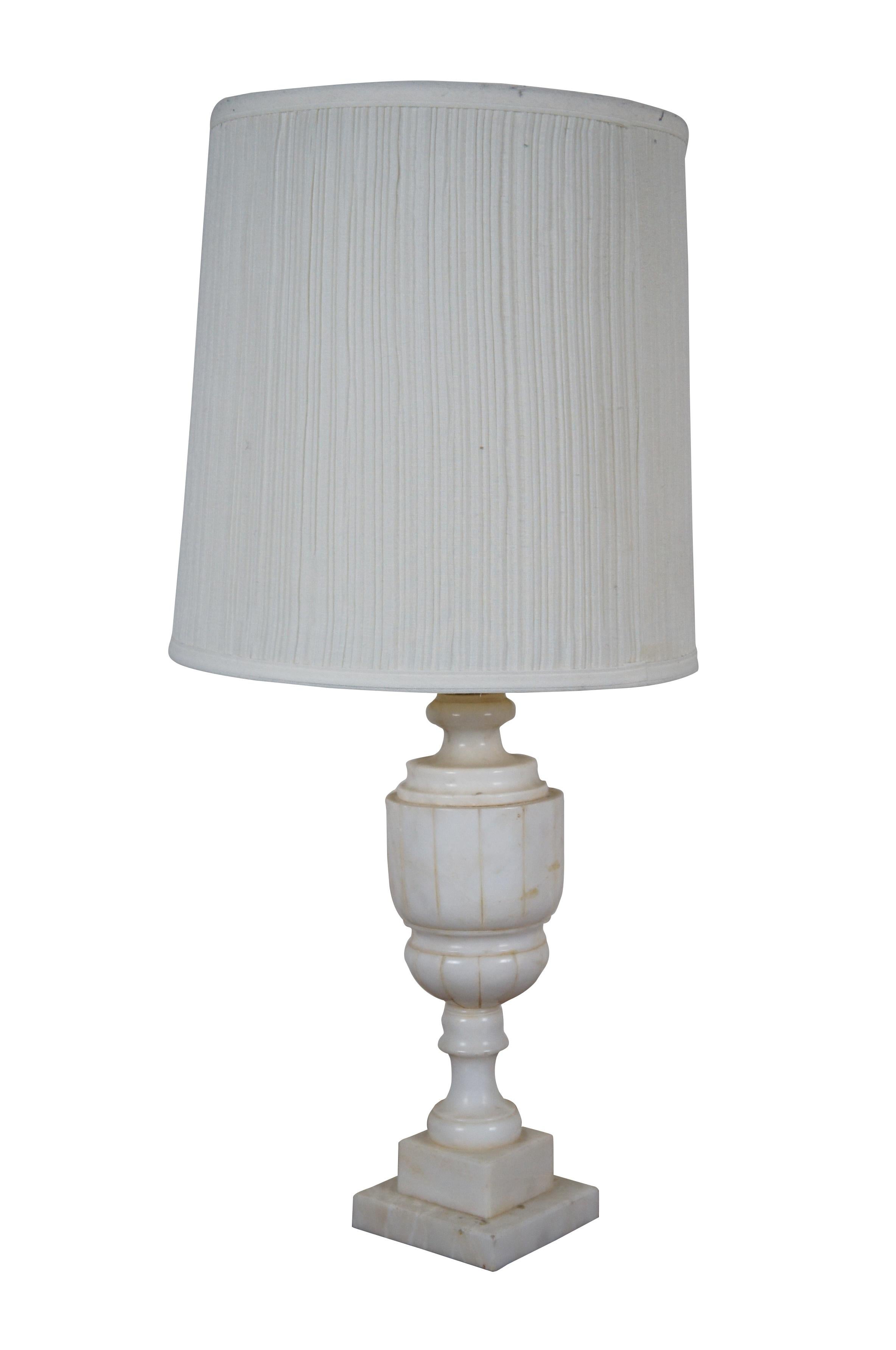 Pair of antique alabaster / white marble table lamps, carved in the shape of neoclassical urns. Lamps include dark, turned finials, harps, and pleated cloth shades.

Dimensions:
5