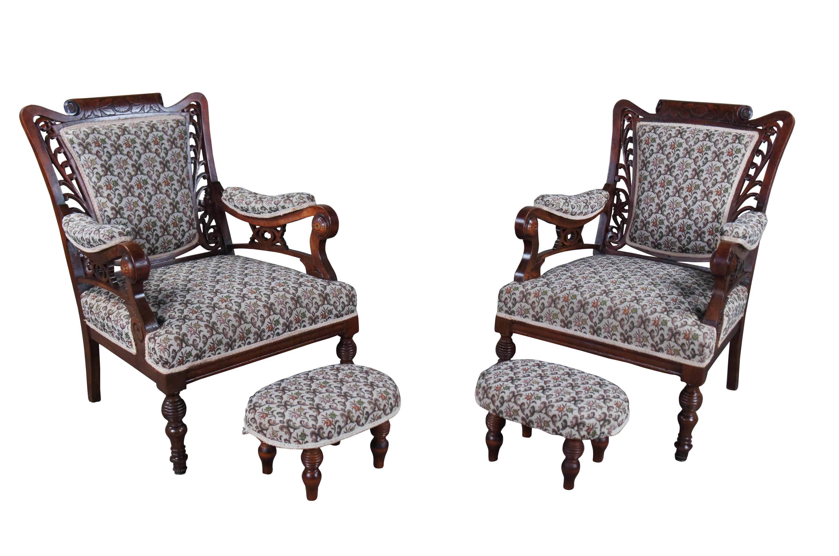 2 impressive Victorian era library, club or parlor arm chairs and ottomans. Made from mahogany with a pierced foliate back, downswept padded arms with accompanied S scroll supports, turned wheel medallions and geometric floral upholstery. Crest rail