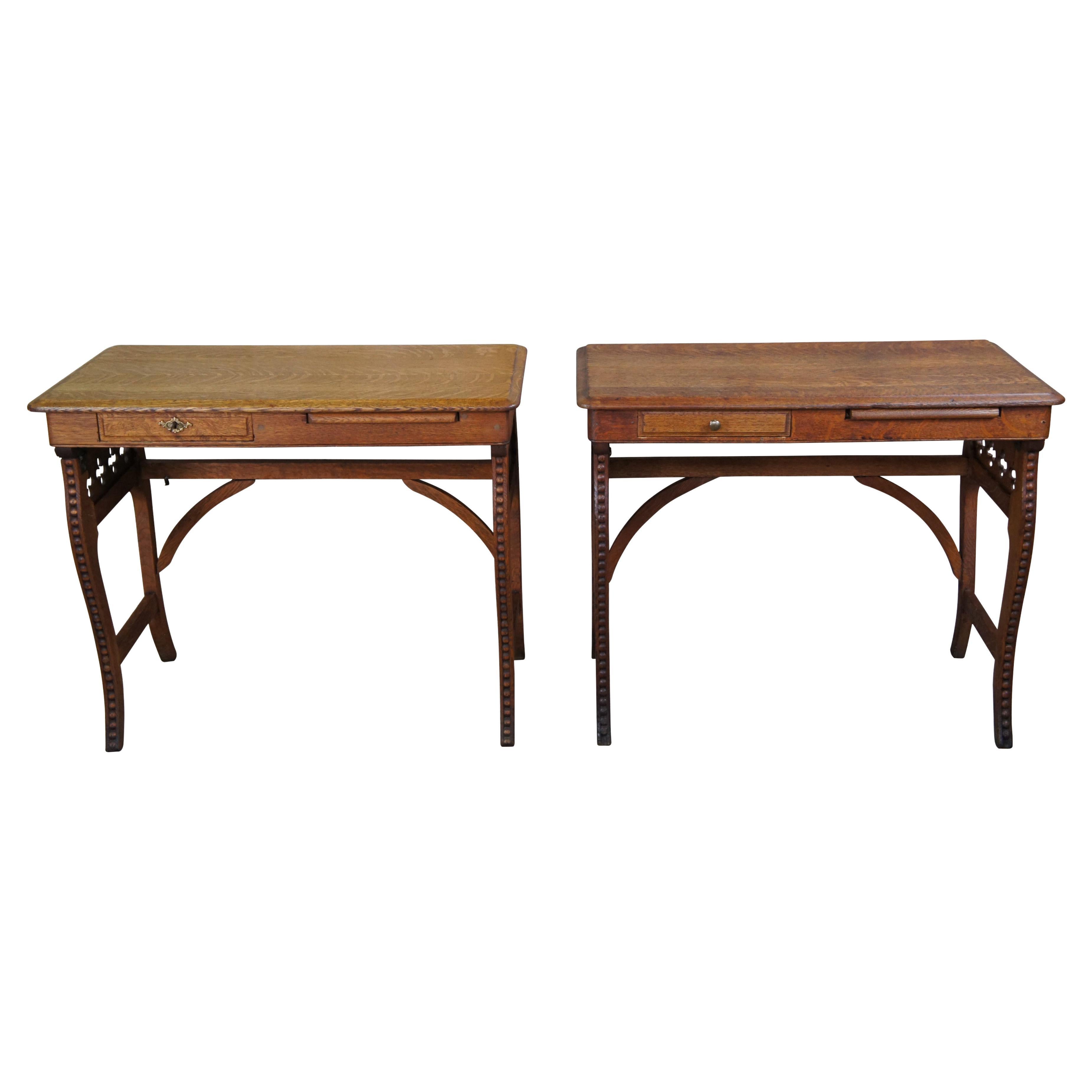 Pair of two antique Victorian Arts & Crafts folding Campaign desks. Made of quartersawn oak featuring Gothic quatrefoil and beaded carved accents with drawer and pull out writing surface. Neatly folds for travel.

Measures: 17.75