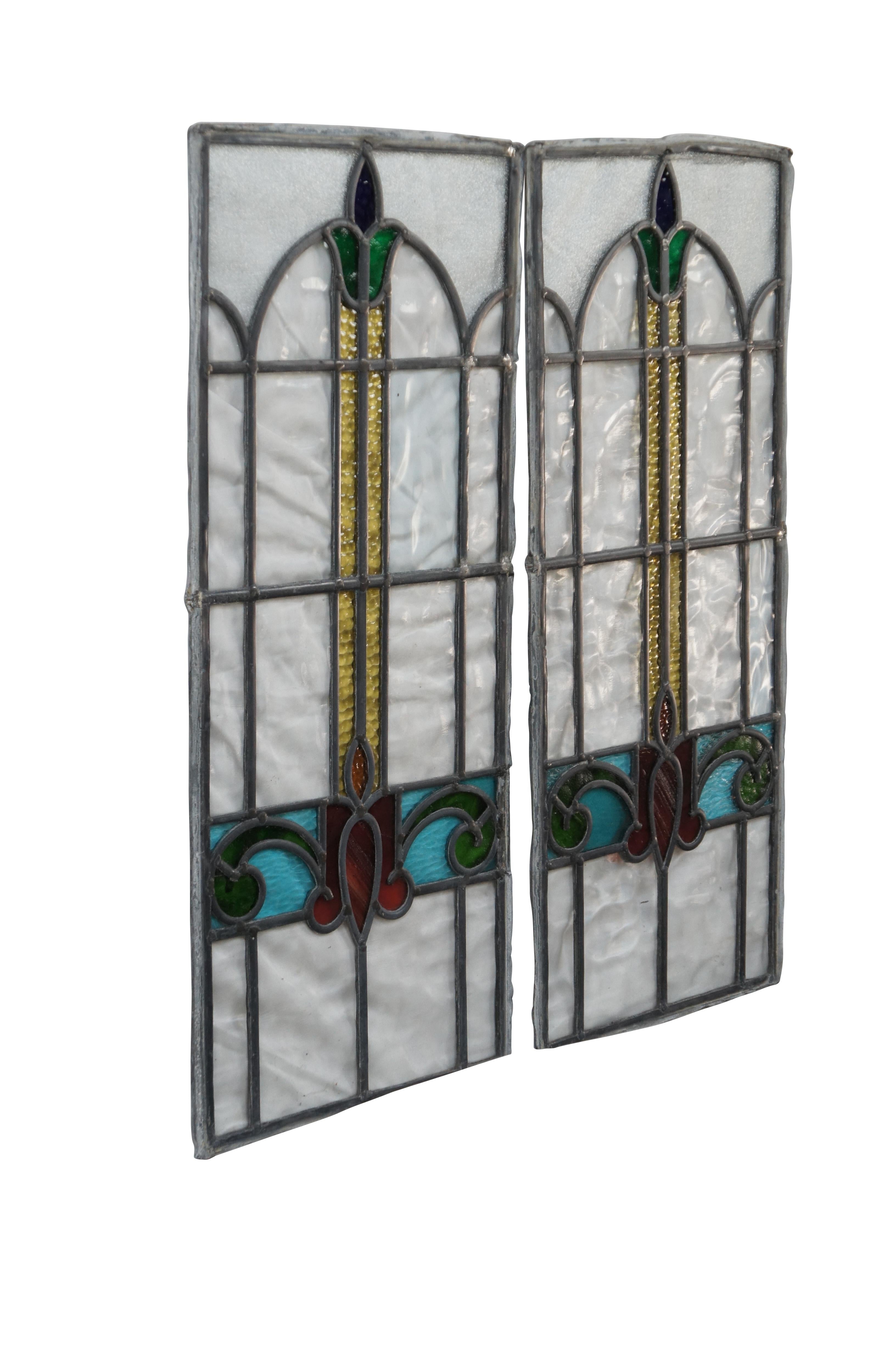 Pair of yellow striped Victorian stained glass window panels.  Features an arched pattern with tulip design along the top and scrolled pattern towards the bottom.  

Dimensions:
30