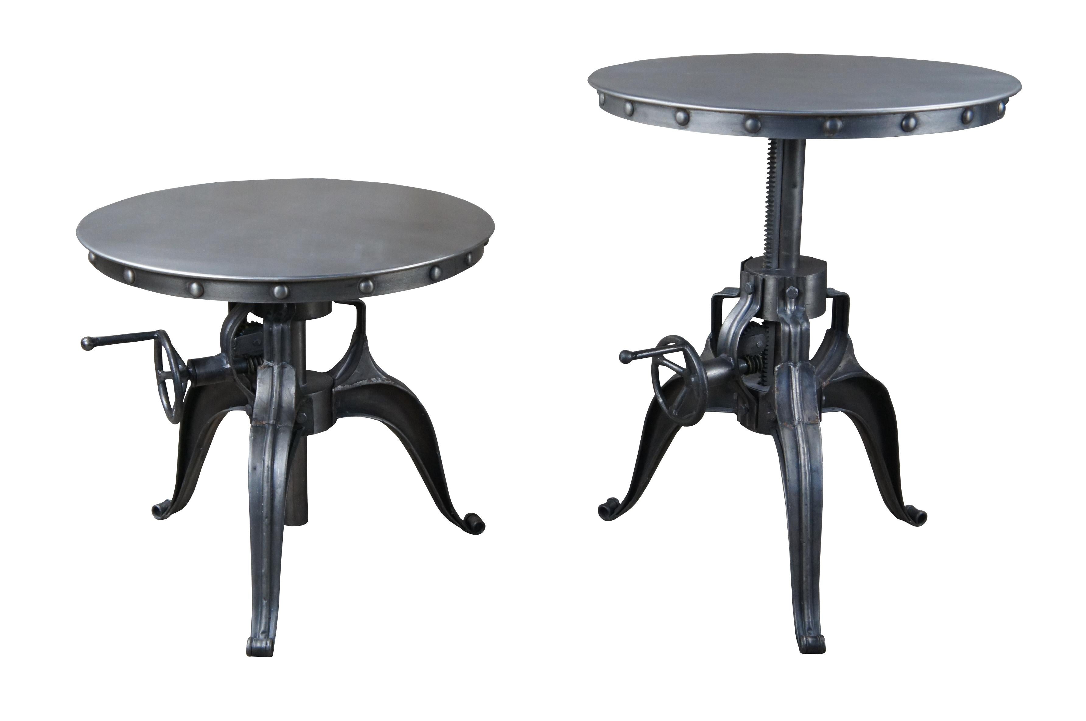 a pair of Weston black crank end table by Arhaus. This metal table features a round surface with nailhead trim to apron and crank mechanism to lower pedestal base.

Measures: 22