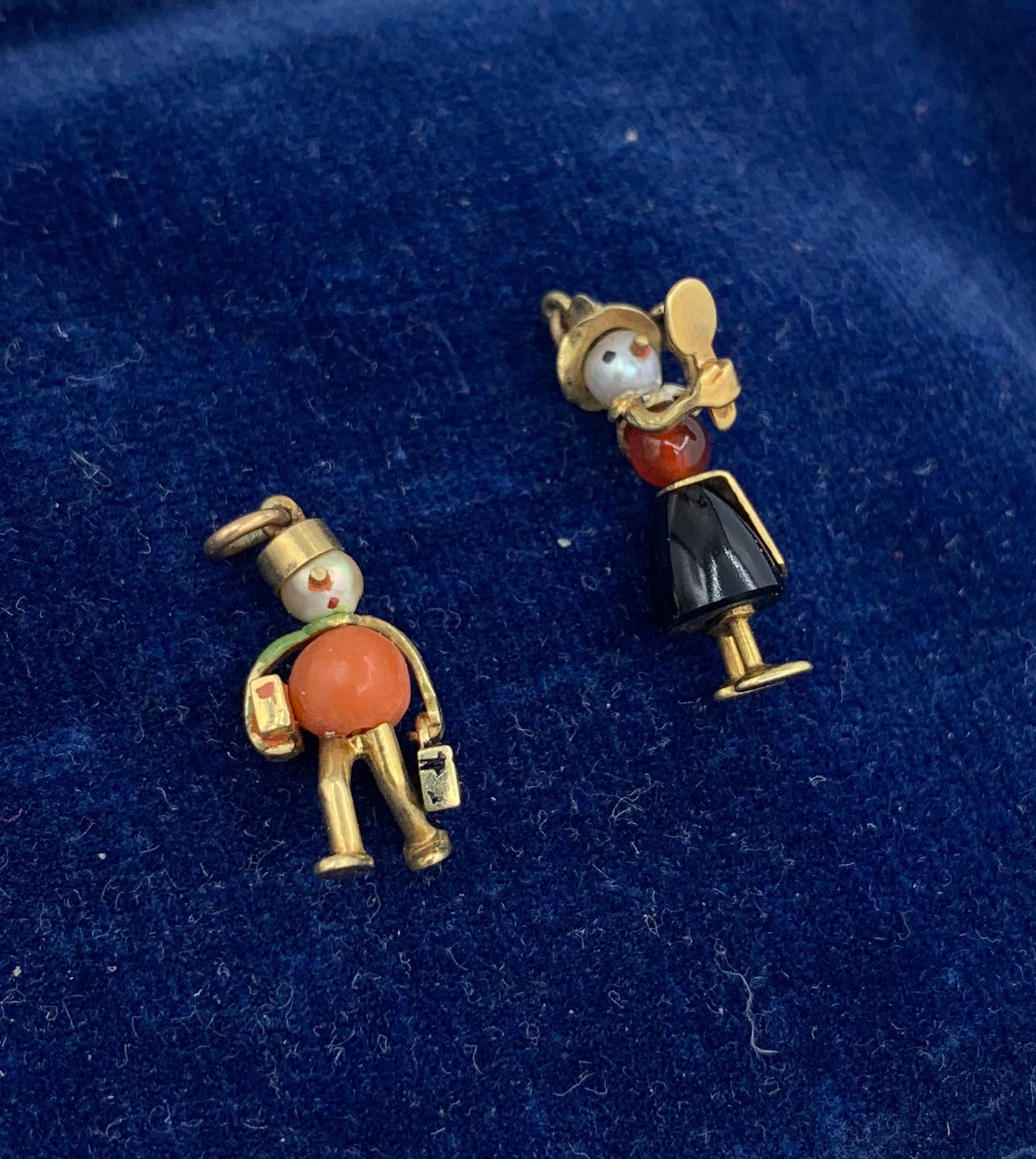 THIS IS A WONDERFUL PAIR OF JEWELED ANTIQUE ART DECO PENDANTS OR CHARMS IN THE FORM OF BELLHOP CARRYING SUITCASES AND A LADY WITH A HAT LOOKING AT HERSELF IN THE MIRROR.  THE CHARMS ARE ABSOLUTELY CHARMING AND DELIGHTFUL.  THE BELLHOP CARRIES THE